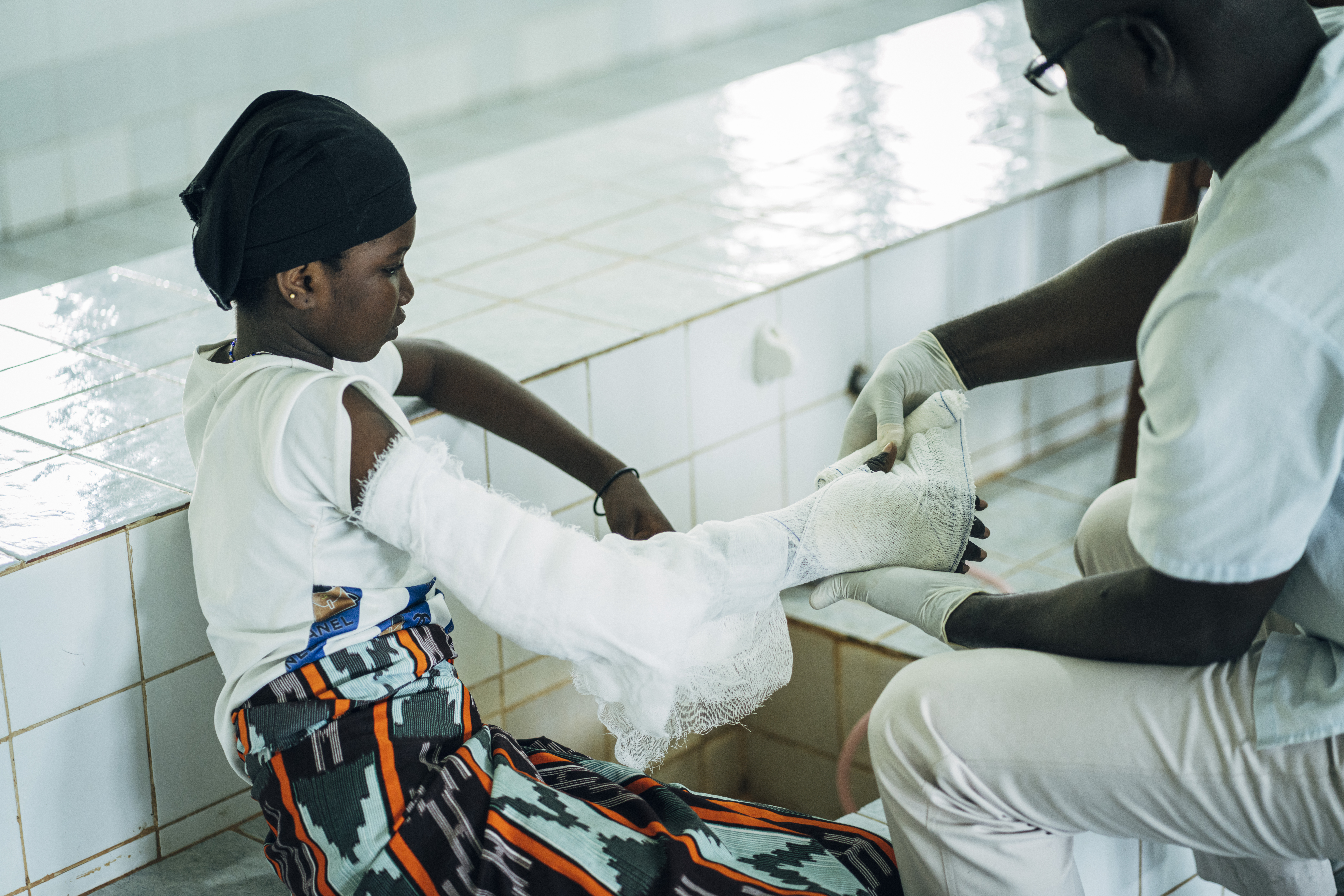 Kanjatou Nakanabo, de 14 años, en la sala de curas, donde el enfermero Deabo Romy le venda el brazo afectado. 