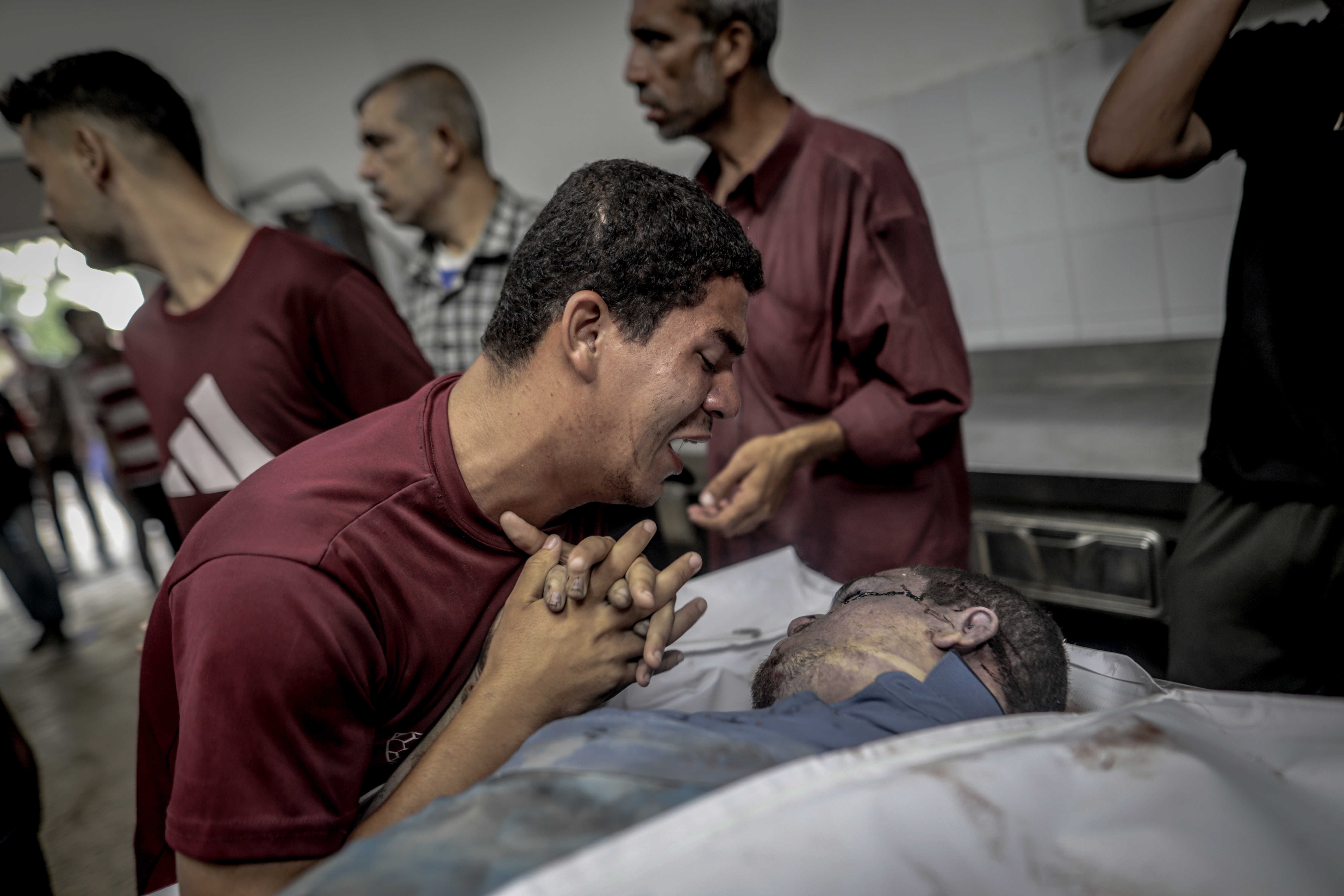Un hombre en la morgue del hospital Al Shifa, en el norte de Gaza, toma la mano de una víctima de un ataque israelí en el campo Al Shati, también en el norte, este miércoles 9 de julio