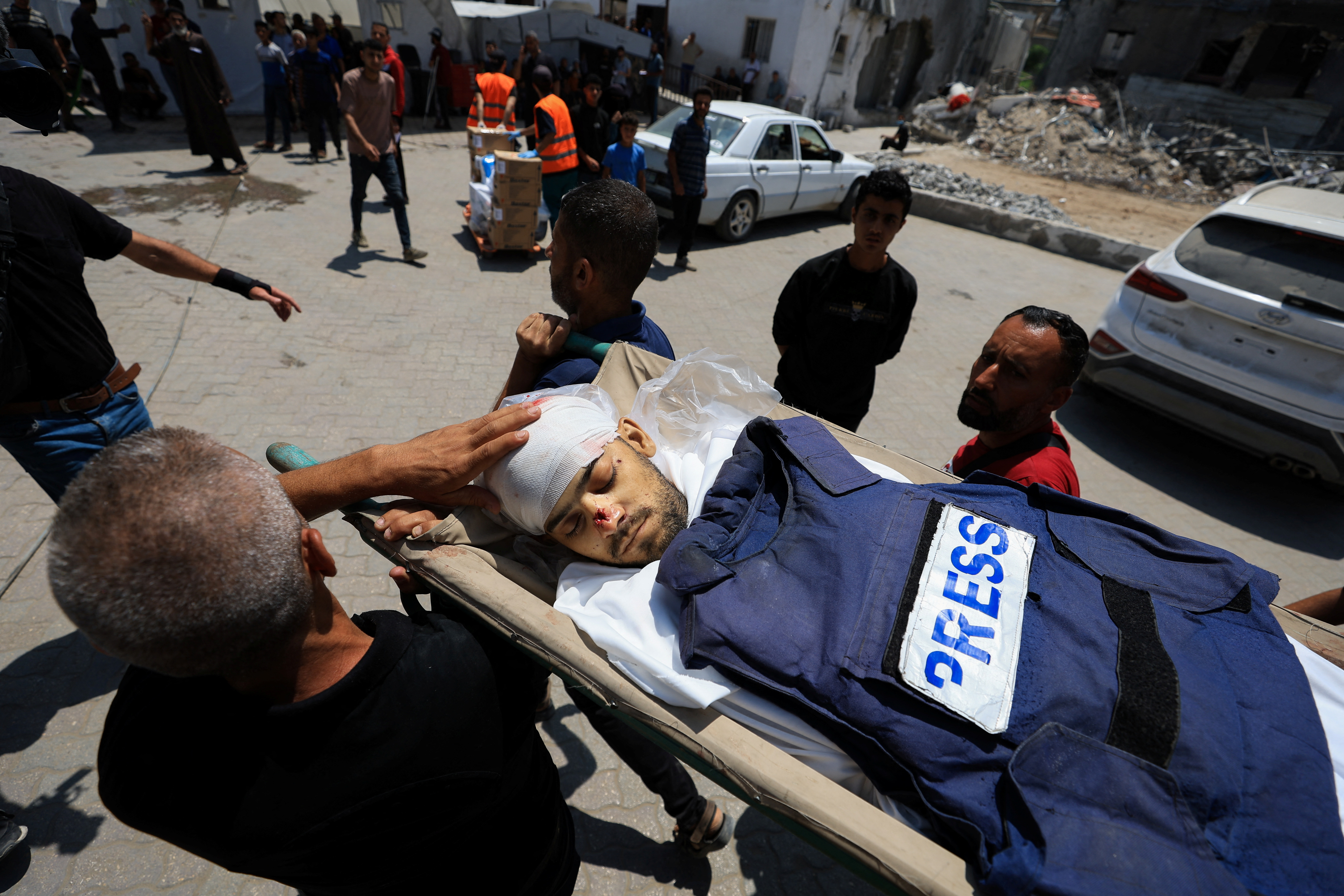 Un grupo de personas carga el cuerpo de un periodista asesinado por un ataque israelí en Ciudad de Gaza, este jueves 5 de junio.