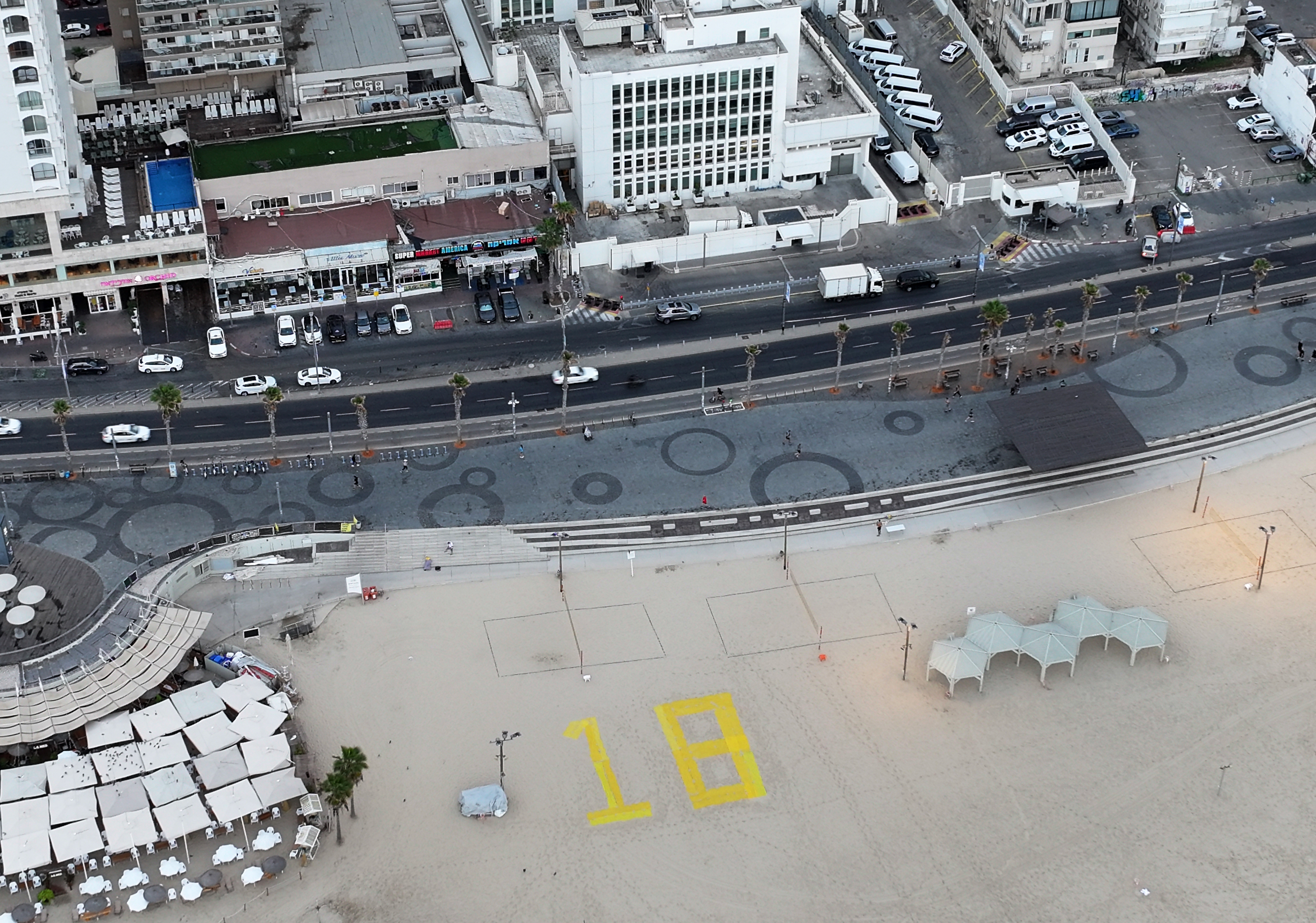 Vista aérea de una playa de Tel Aviv con el número 18 dibujado por el número de cadáveres de rehenes israelíes que quedan por regresar.