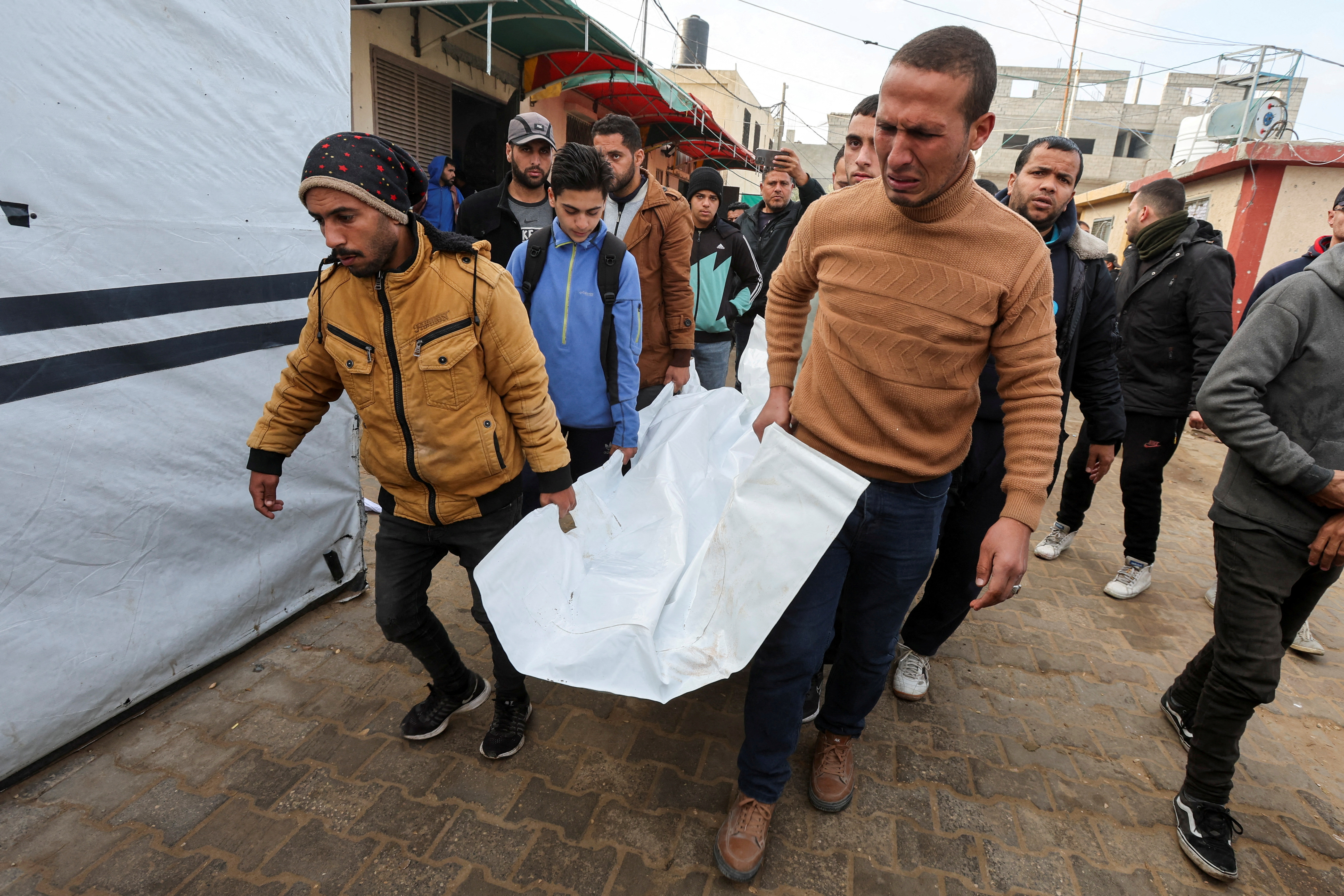 Ciudadanos palestinos trasladan el cadáver de una de las víctimas de los ataques israelíes en Deir al Balah, Gaza, este lunes. 