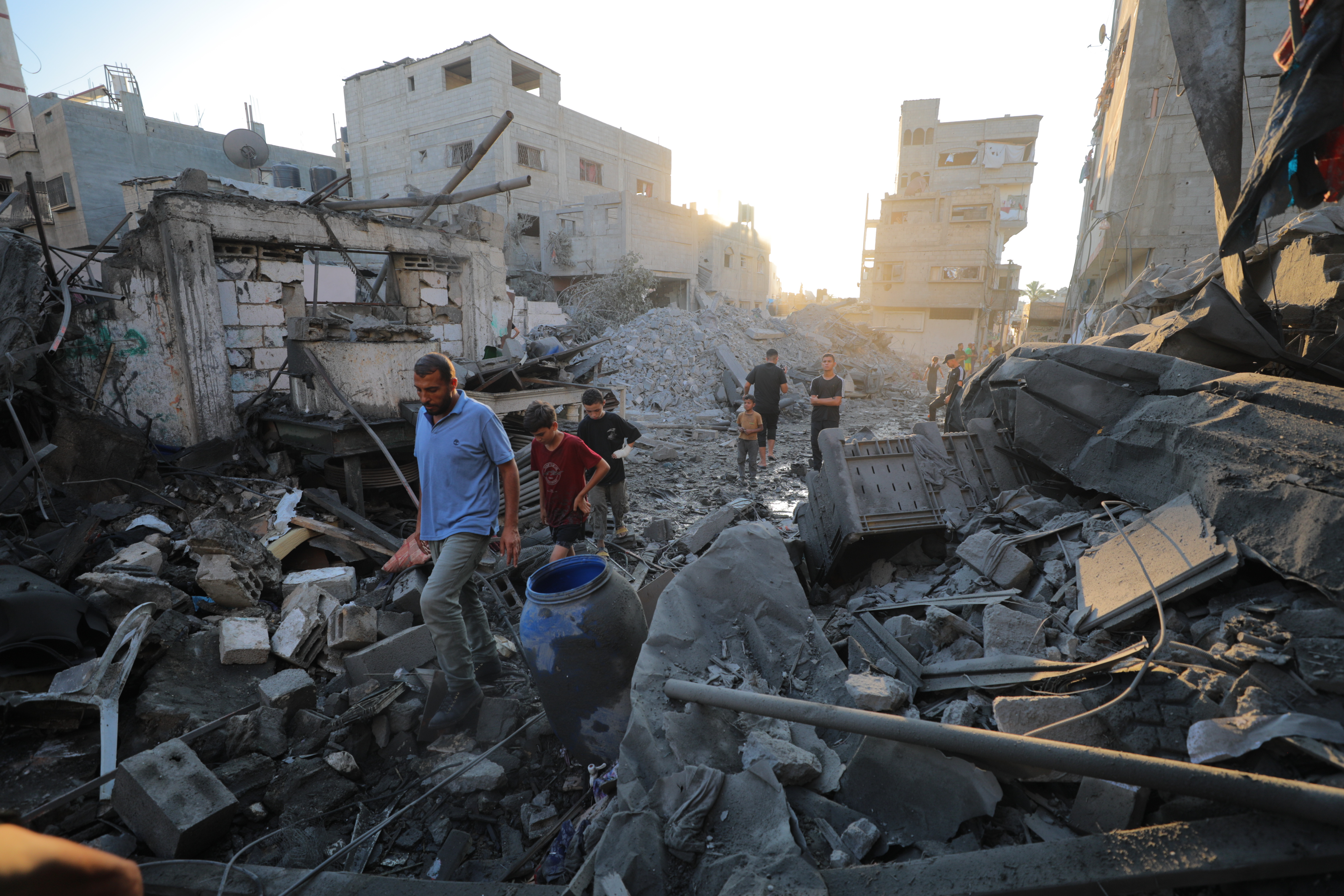 Palestinos caminan entre las ruinas de edificios destruidos por Israel en el campo de refugiados de Al Bureij, en el centro del enclave, el 23 de julio de 2025.