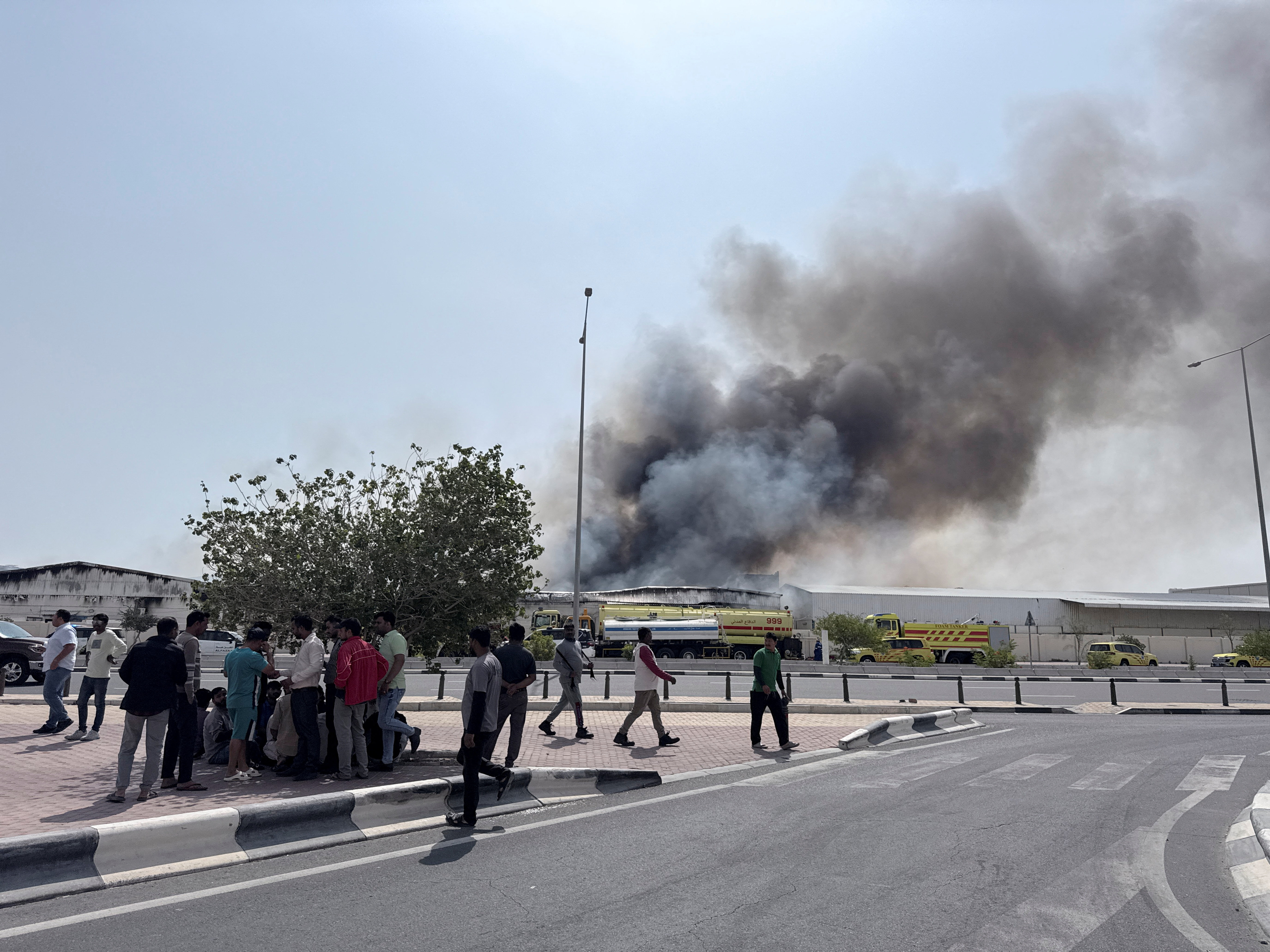 People gather as smoke rises at the Industrial Area after reported Iranian missile attacks, following United States and Israel strikes on Iran, in Doha, Qatar, March 1, 2026. REUTERS/Mohammed Salem