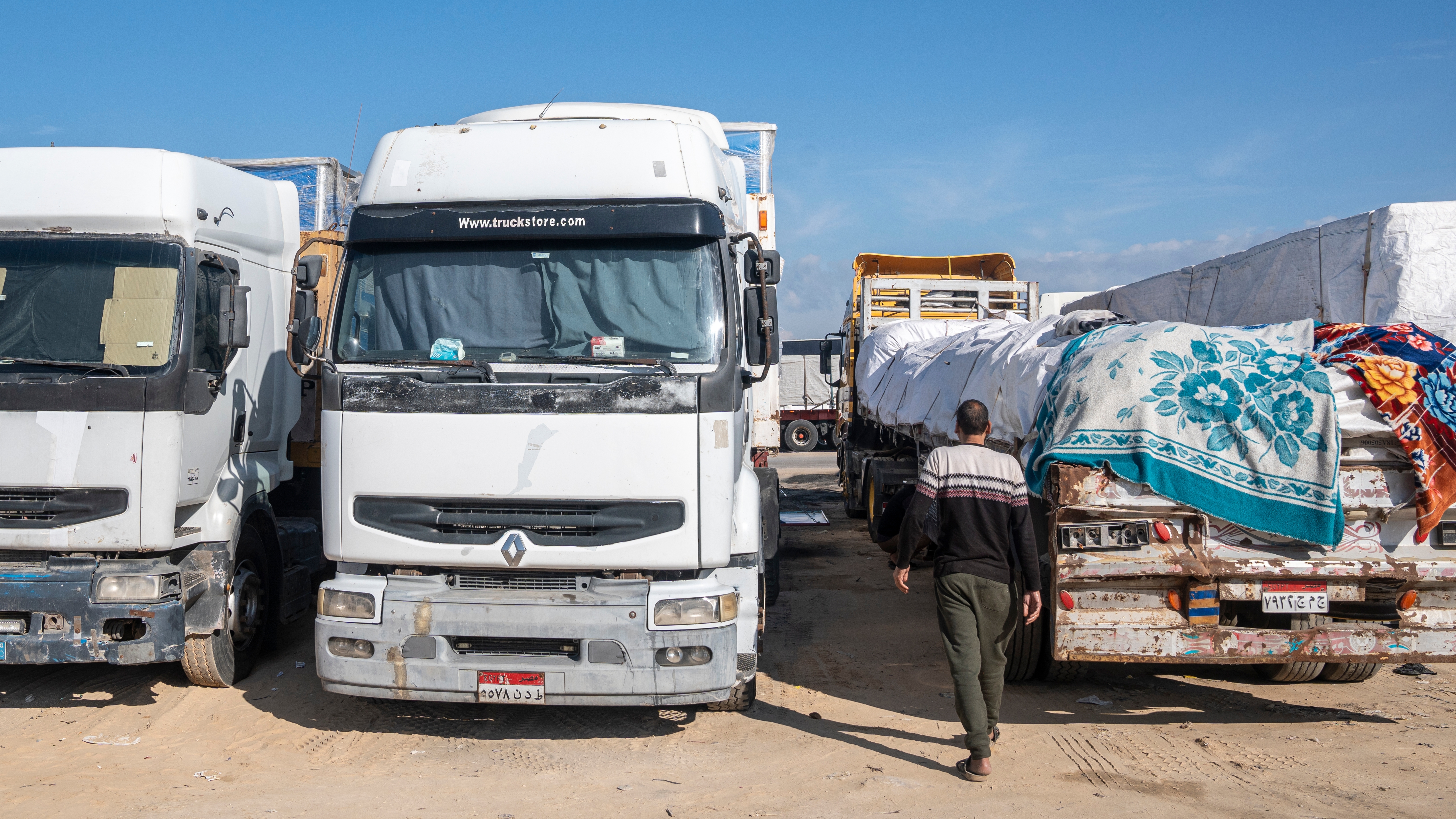 Camiones con ayuda humanitaria estacionados en la ciudad egipcia de Al-Arish, cerca de la frontera con la Franja, aguardando para entrar a Gaza una vez comience a regir la tregua, este 17 de enero de 2025.