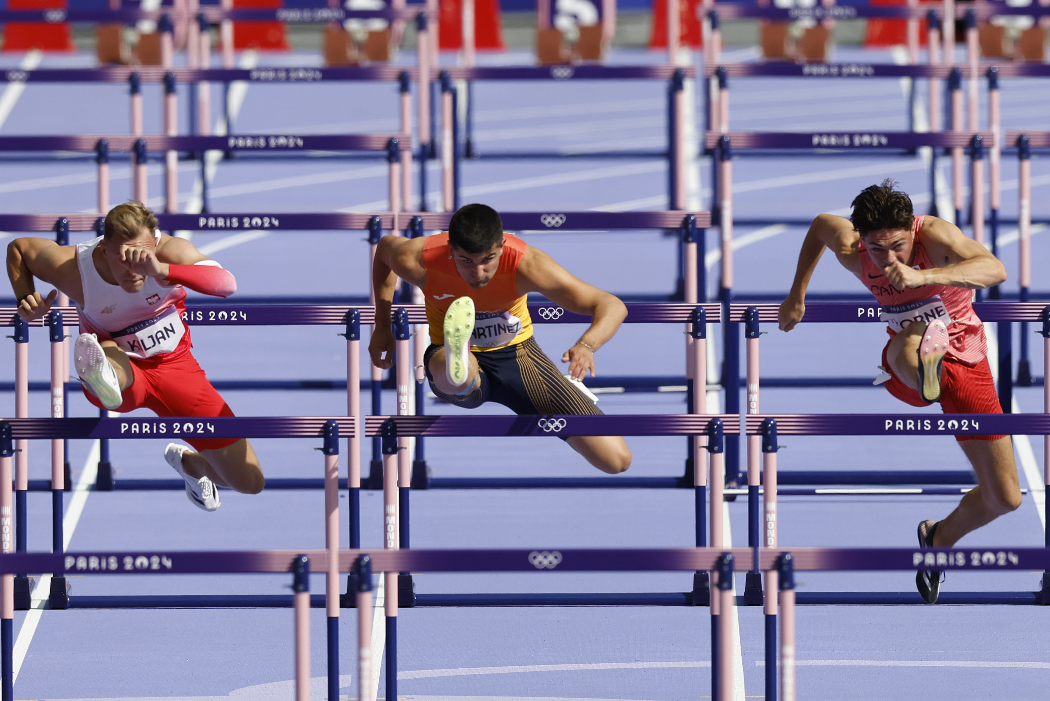 PARÍS, 06/08/2024.- Los atletas (de i a d) EKrysztof Kiljan de Polonia, Asier Martínez de España y Craig Thorne de Canada compiten en la repesca de los 110m valla masculinos, este lunes, en la capital gala. EFE/ Miguel Toña
