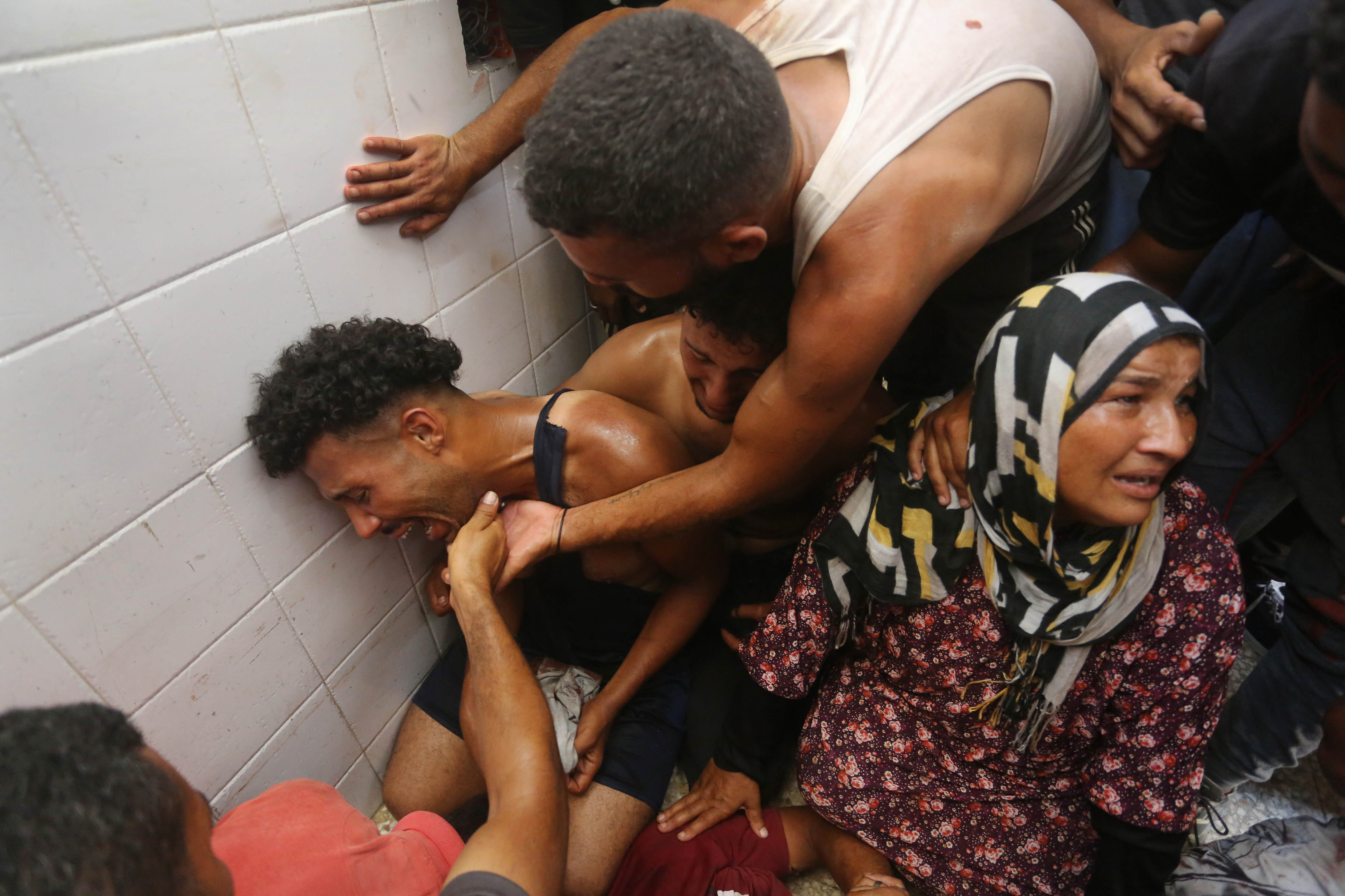 Relatives of the Palestinians killed as result of Israeli attacks on the Bureij Refugee Camp mourn as the bodies are being brought to Aqsa Martyrs Hospital in Deir al-Balah, Gaza on July 23, 2024. (Photo by Ashraf Amra/Anadolu via Getty Images)