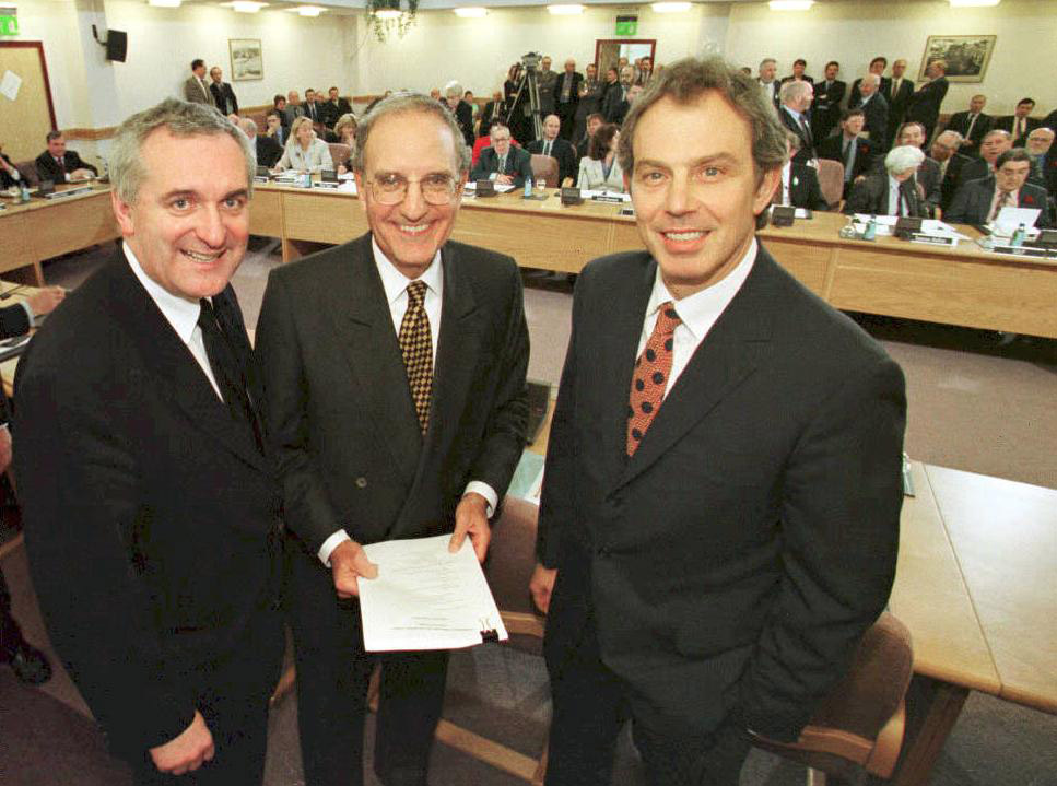 O ex-primeiro-ministro do Reino Unido Tony Blair (à direita), o ex-senador dos EUA George Mitchell (ao centro) e o ex-primeiro-ministro irlandês Bertie Ahern (à esquerda) em 10 de abril de 1998, após a assinatura do Acordo da Sexta-Feira Santa.