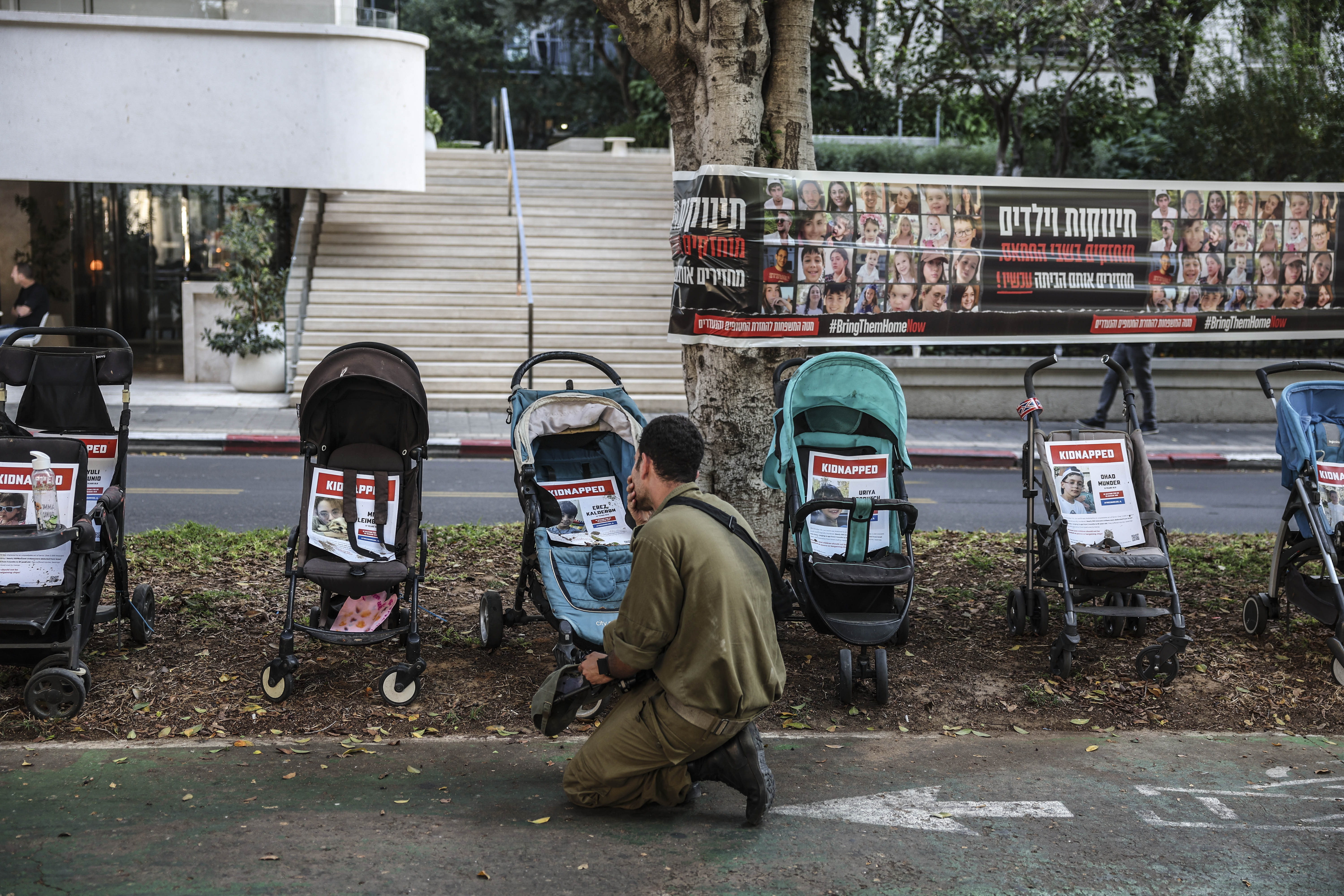 Un soldado delante de un memorial por los niños secuestrados el 7 de octubre, en una calle del centro de Tel Aviv, el 5 de noviembre.
