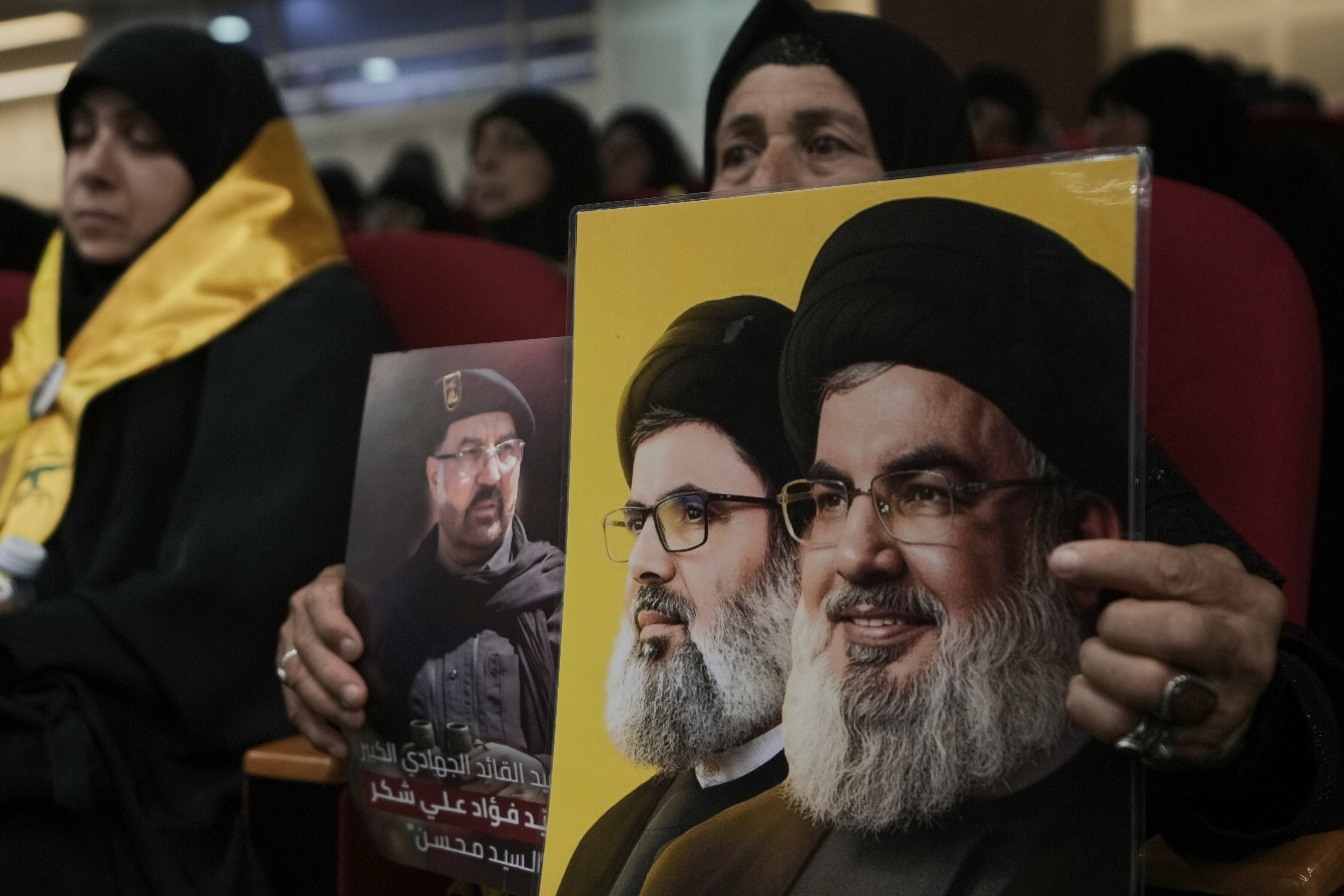 Una mujer sostiene las imágenes de altos cargos del partido milicia libanés Hezbolá en el aniversario de la muerte de uno de sus comandantes, el 30 de julio de 2025, en Beirut.