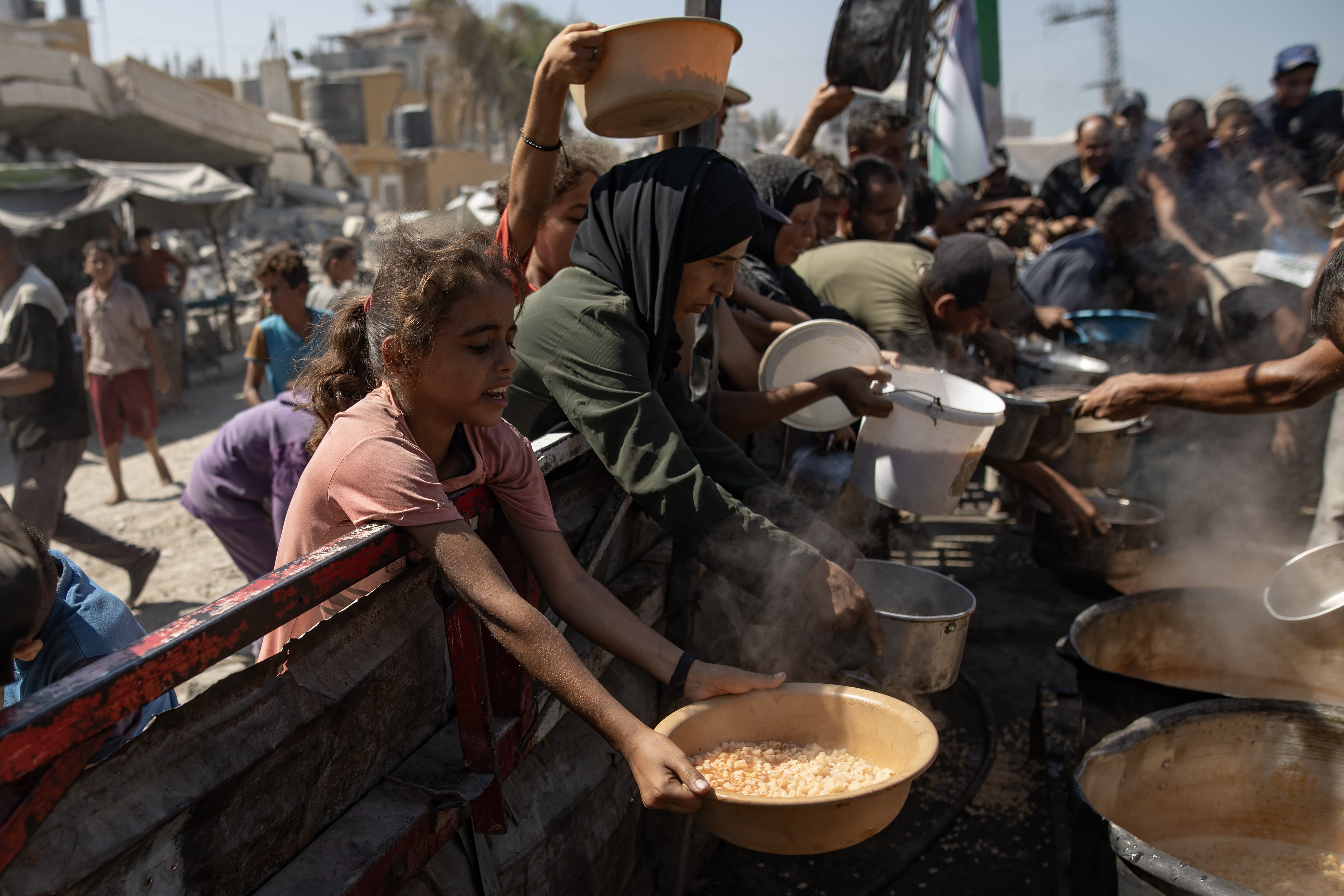 Gaza City (-), 12/09/2025.- Palestinians, including children, hold pots as they queue to receive food from a kitchen that provides free food for displaced people in Gaza City, northern Gaza Strip, 12 September 2025. According to the UN, around 90 percent of the population, or 1.9 million people, in Gaza have been displaced since the start of the conflict. EFE/EPA/HAITHAM IMAD
