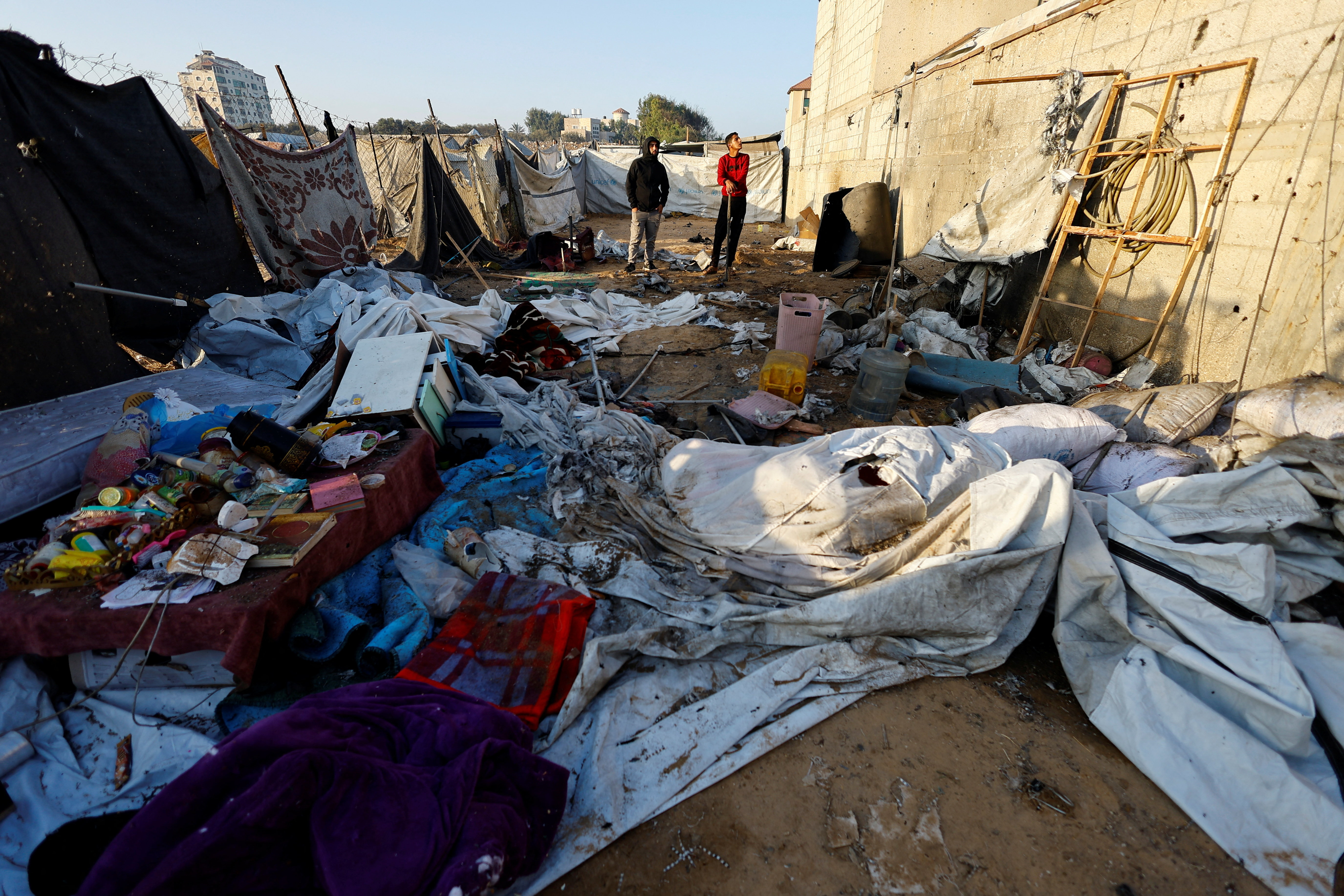 Palestinians inspect the site of Sunday's Israeli strike on a tent, according to the civil defense, in Nuseirat, central Gaza Strip, October 20, 2025. REUTERS/Mahmoud Issa
