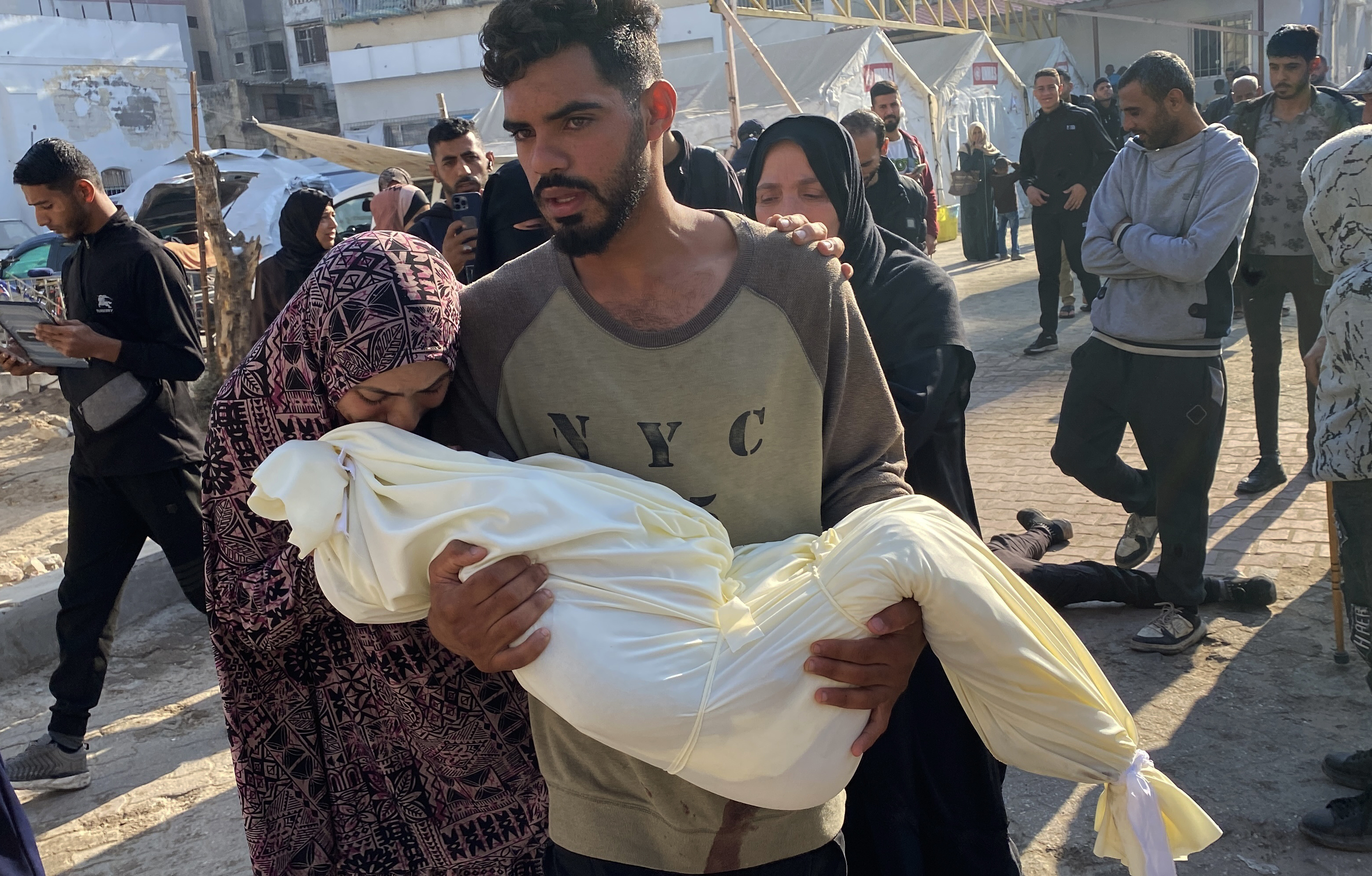 Un hombre sostiene el cadáver de un niño palestino muerto en un bombardeo israelí este viernes en Gaza.