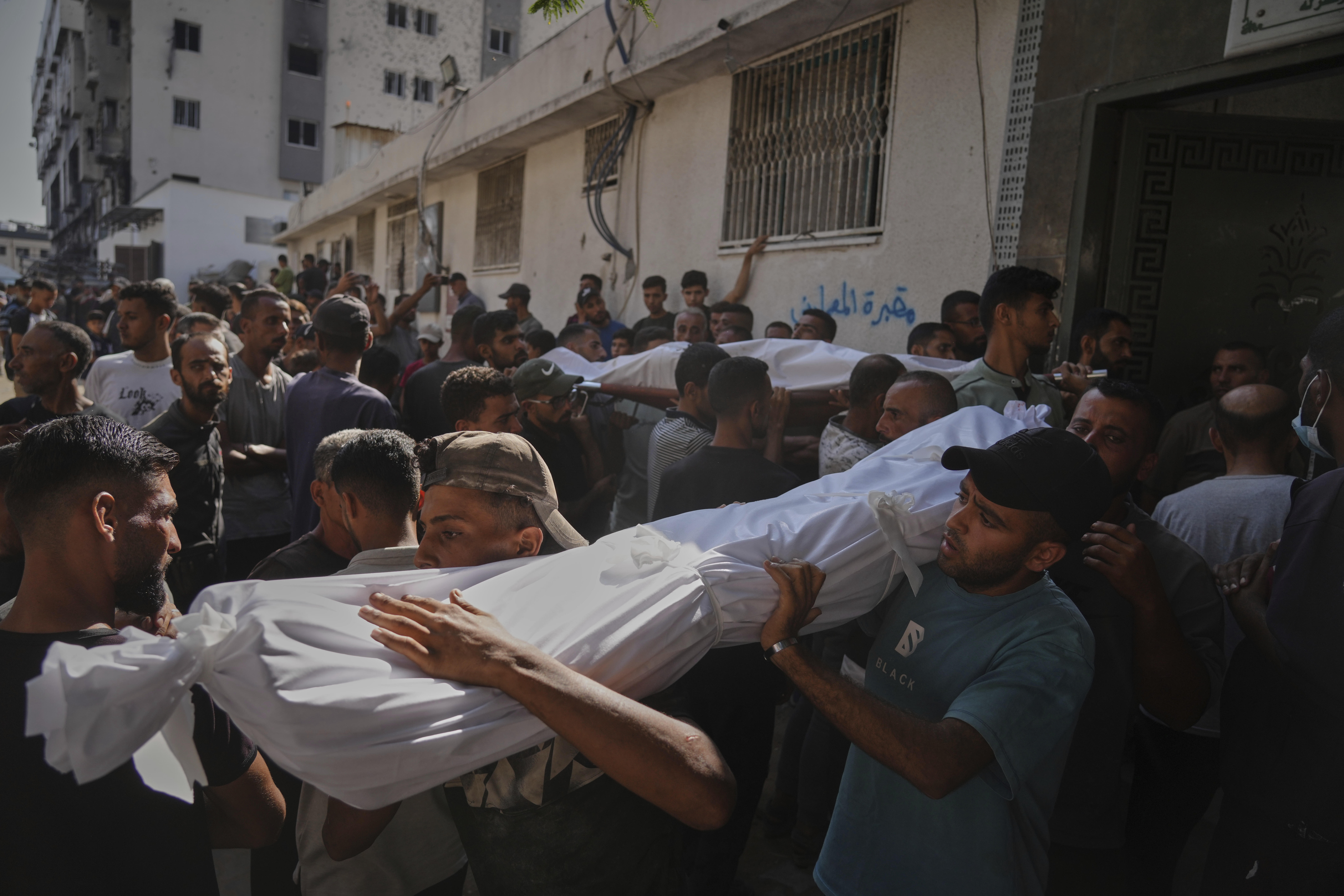 Un grupo de personas carga el cuerpo de una persona fallecida mientras intentaba alcanzar alimentos transportados por un camión que volcó sobre una multitud en el norte de Gaza, este miércoles 6 de agosto.