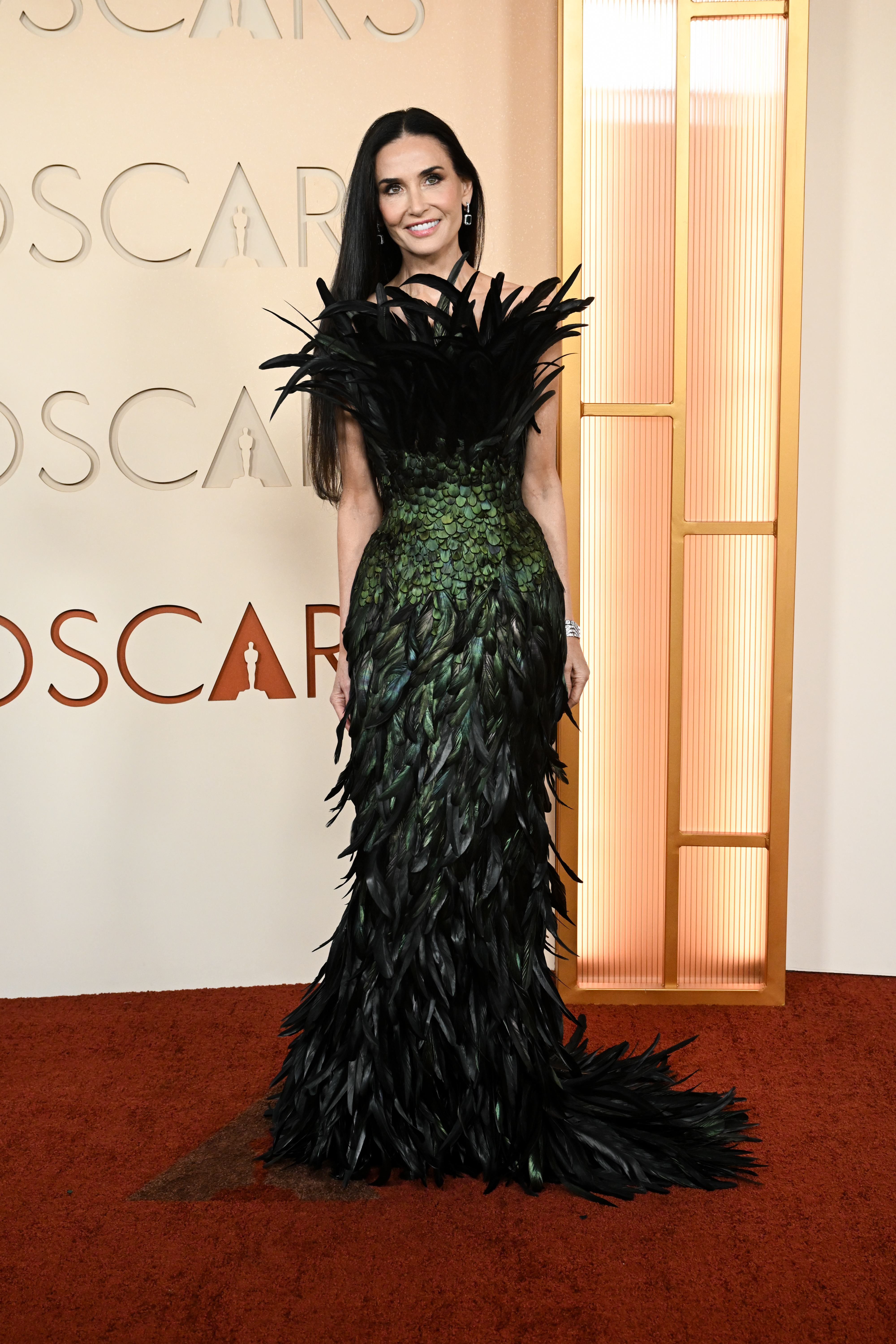 Demi Moore, que el año pasado estuvo nominada al Oscar por 'La sustancia', con un espectacular modelo de plumas verde y negro de Gucci.