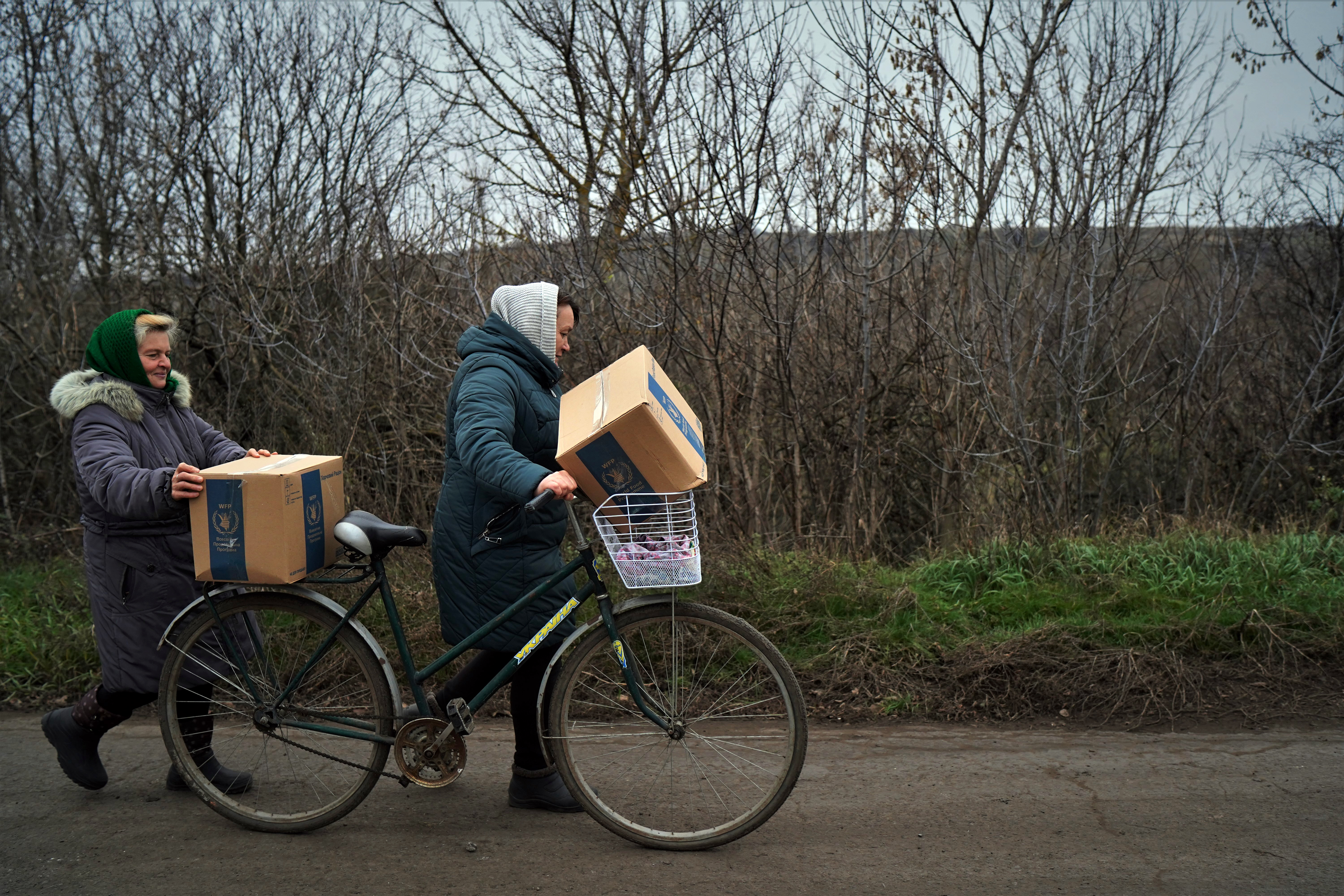 Two women returning home in Hnilitsia after collecting food rations on November 11.