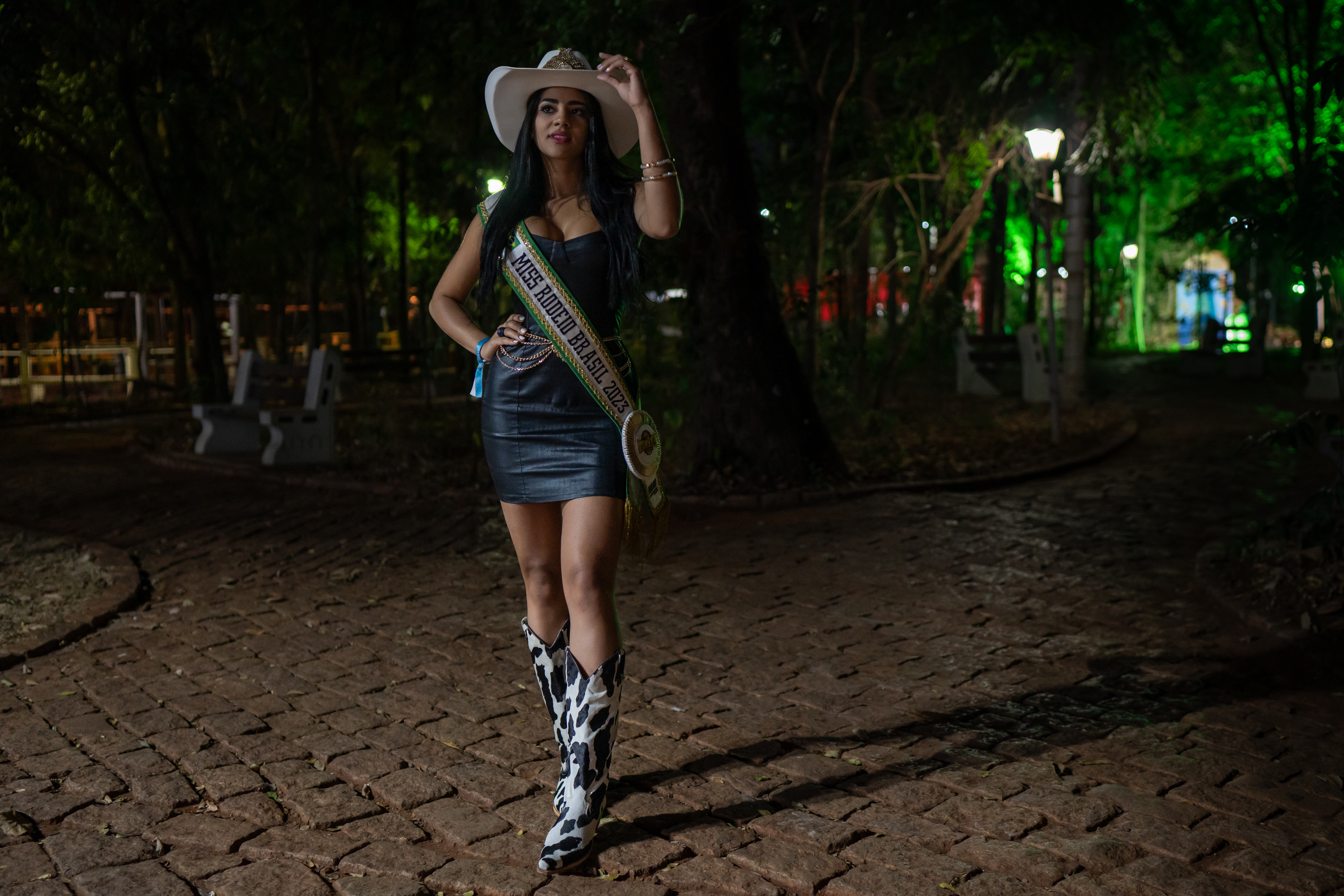Danielle Macedo, advogada de 26 anos e Miss rodeio Brasil 2023, posa ao lado do estádio de rodeio na festa de Barretos. 