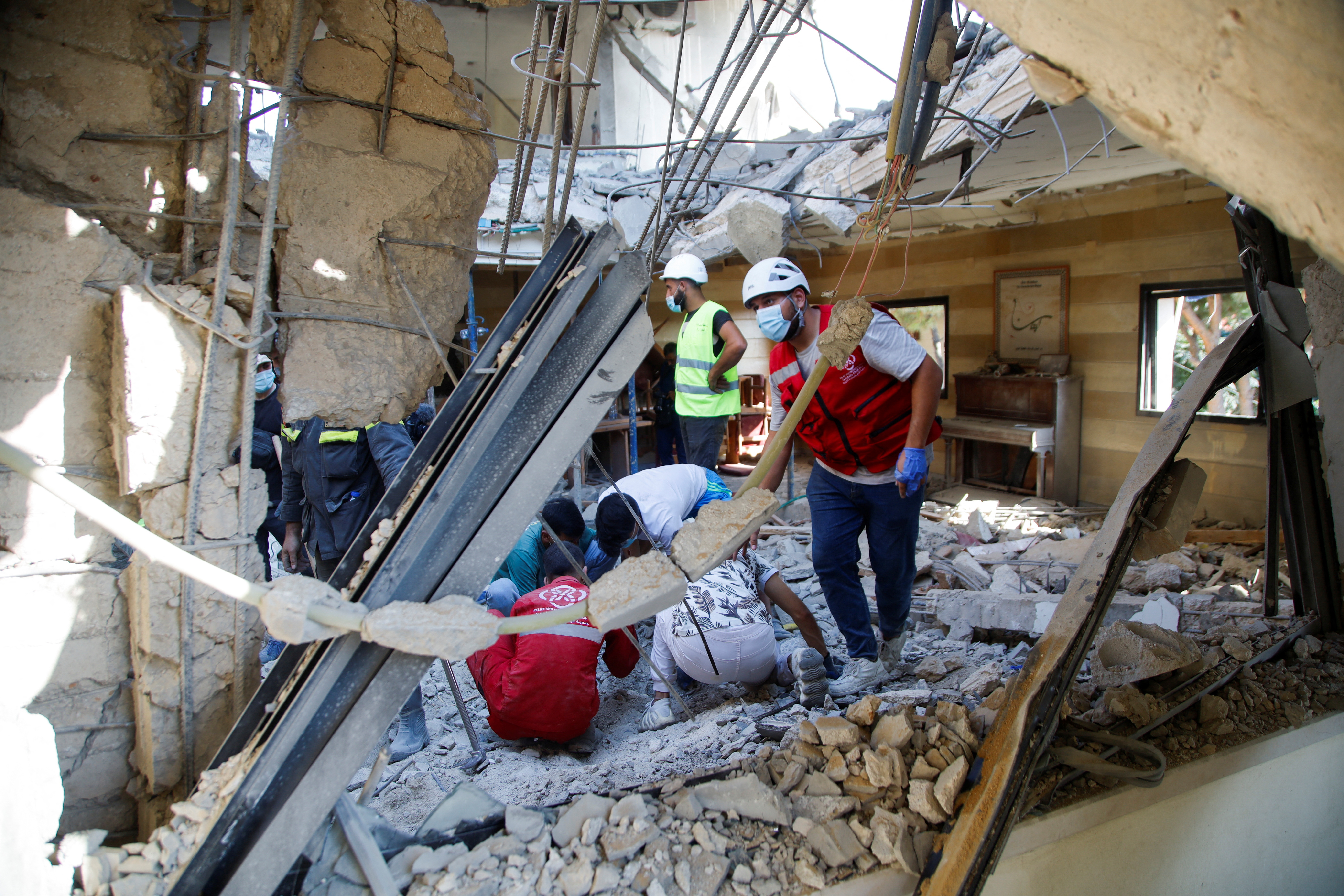 Rescuers and people inspect the site of an Israeli strike that hit a building, amid ongoing cross-border hostilities between Hezbollah and Israeli forces, in the town of Wardaniyeh, Lebanon October 9, 2024. REUTERS/Stringer