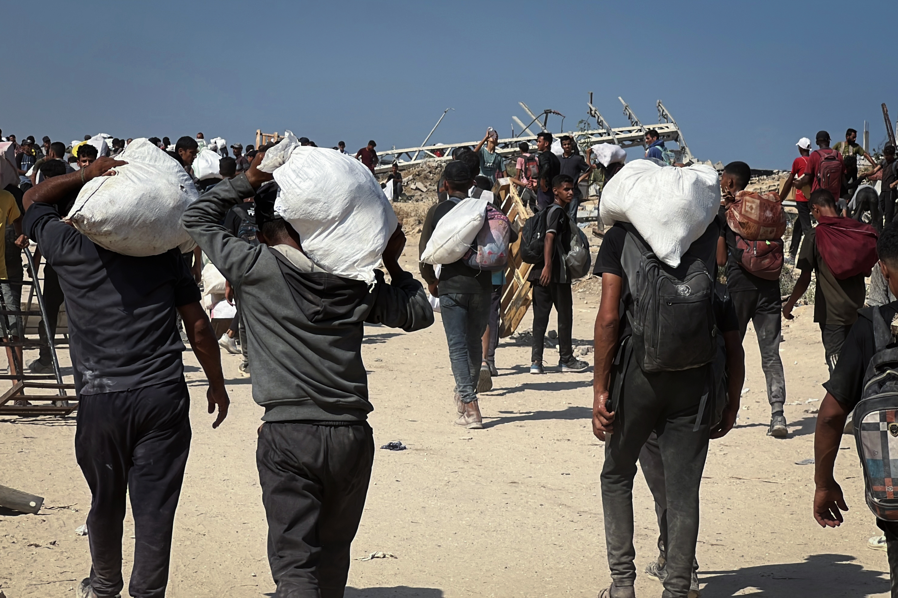 03 August 2025, Palestinian Territories, Nusairat: Palestinians carry aid supplies which they received from the U.S.-backed Gaza Humanitarian Foundation (GHF), in the central Gaza Strip. Photo: Belal Abu Amer/APA Images via ZUMA Press Wire/dpa/APA Images via ZU / DPA03/08/2025 ONLY FOR USE IN SPAIN