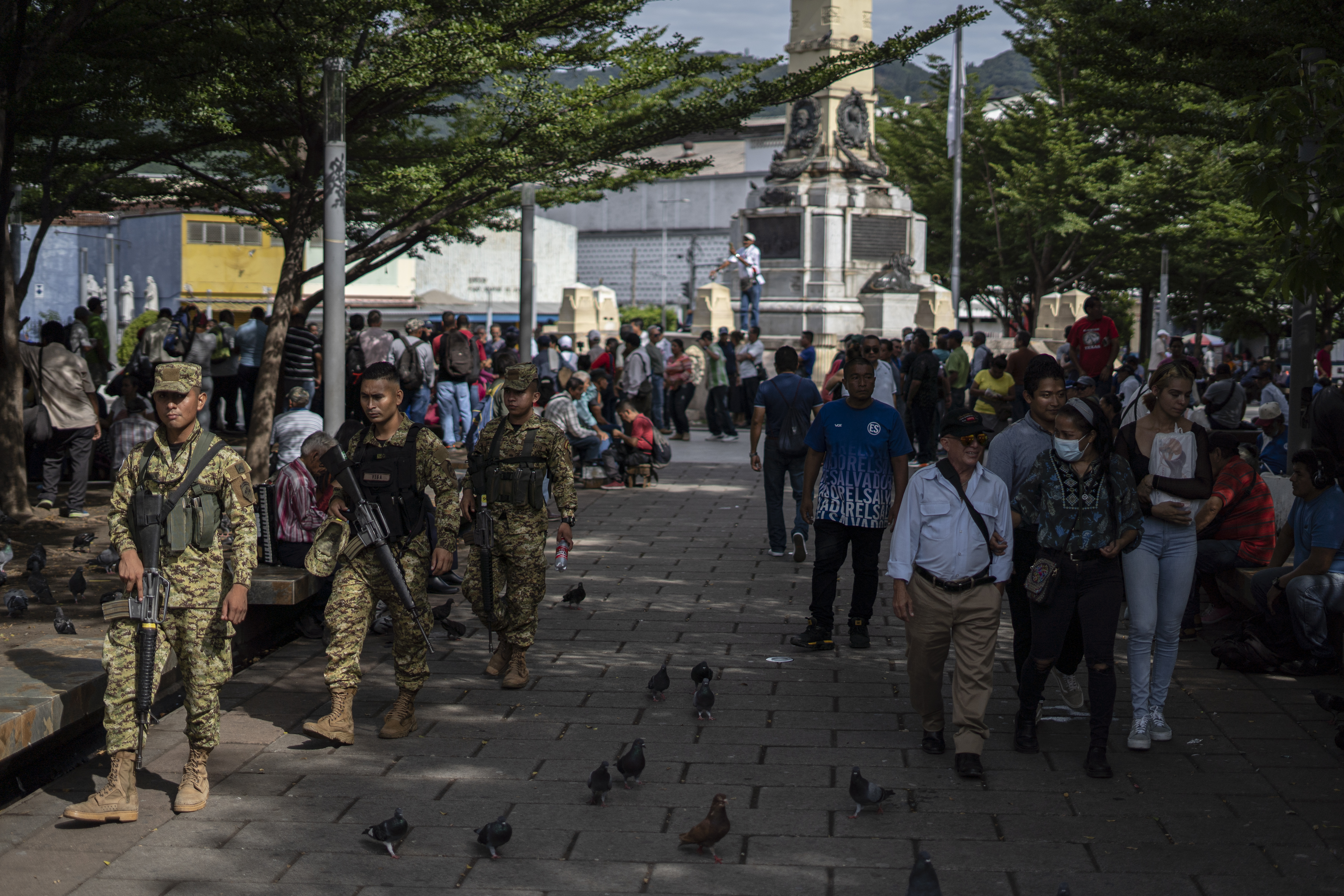 Soldados caminham pela Plaza Libertad, junto com moradores e turistas, no Centro Histórico de San Salvador. 