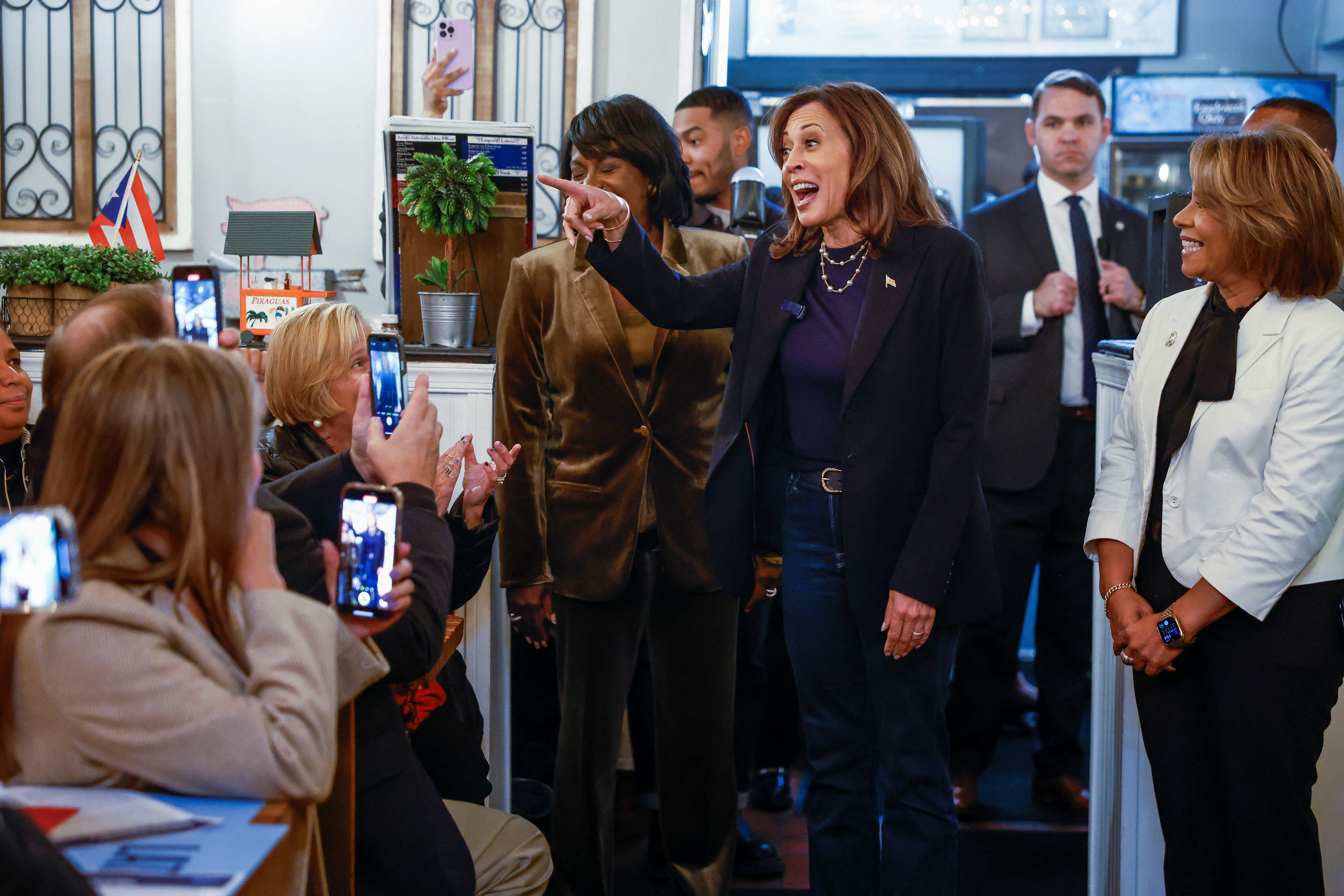 Democratic presidential nominee U.S. Vice President Kamala Harris speaks next to Mayor of Philadelphia Cherelle Parker, Philadelphia City Councilmember Quetcy Lozada and Philadelphia's Puerto Rican community during a visit at the Freddy and Tony's, a locally-owned Puerto Rican restaurant, as she campaigns in Philadelphia, Pennsylvania, U.S. October 27, 2024. REUTERS/Evelyn Hockstein