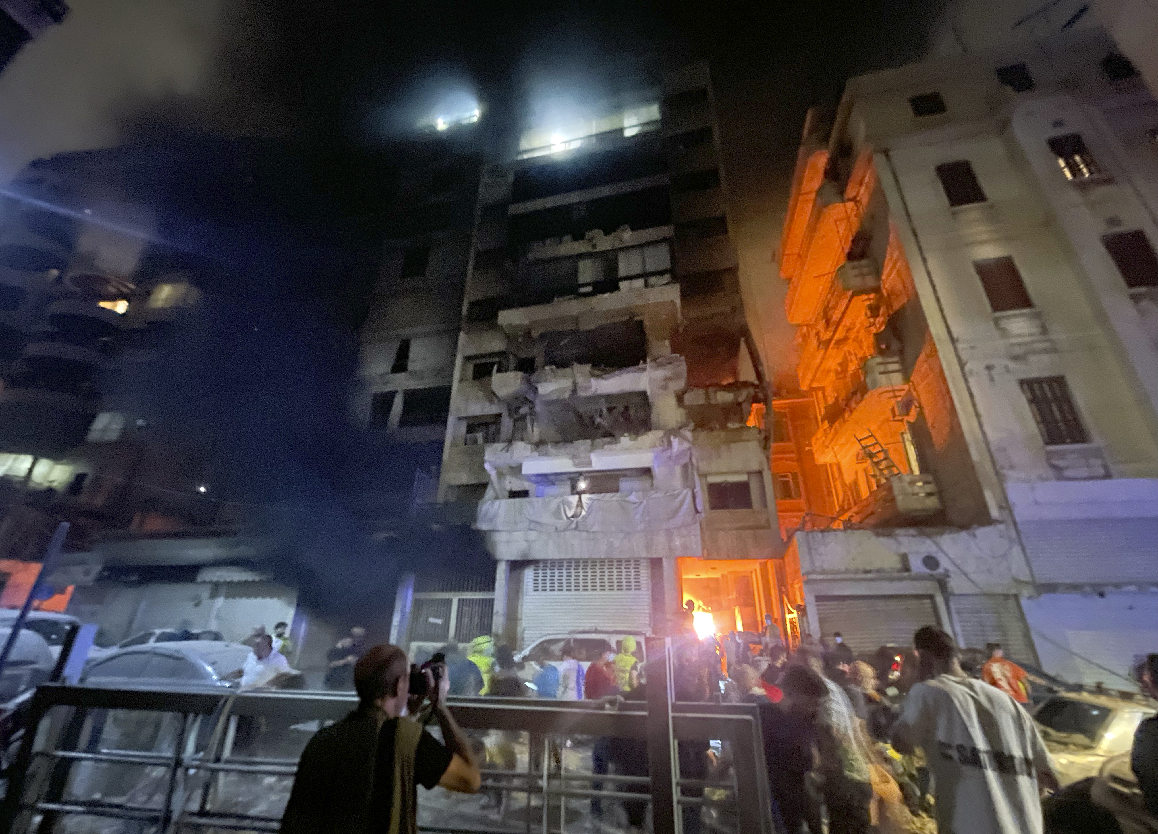 People gathering in front a destroyed building hit by an Israeli airstrike in central Beirut, Lebanon, Thursday, Oct. 10, 2024. (AP Photo/Bilal Hussein)