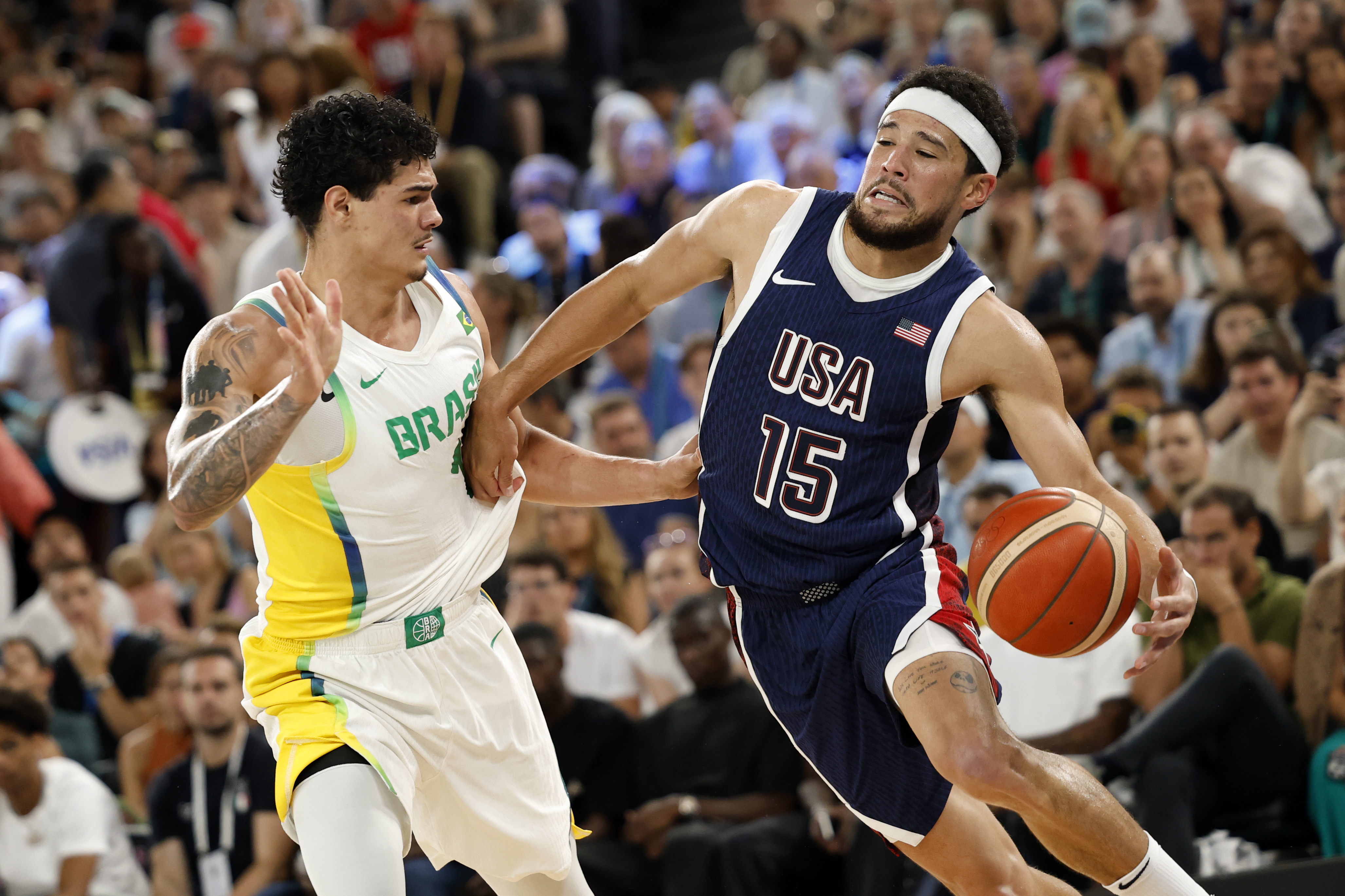 Paris (France), 06/08/2024.- Devin Booker of the US (R) and Gui Santos of Brazil in action during the men's quarterfinal match between Brazil and USA in the Basketball competitions in the Paris 2024 Olympic Games, at the South Paris Arena in Paris, France, 06 August 2024. (Baloncesto, Brasil, Francia) EFE/EPA/CAROLINE BREHMAN
