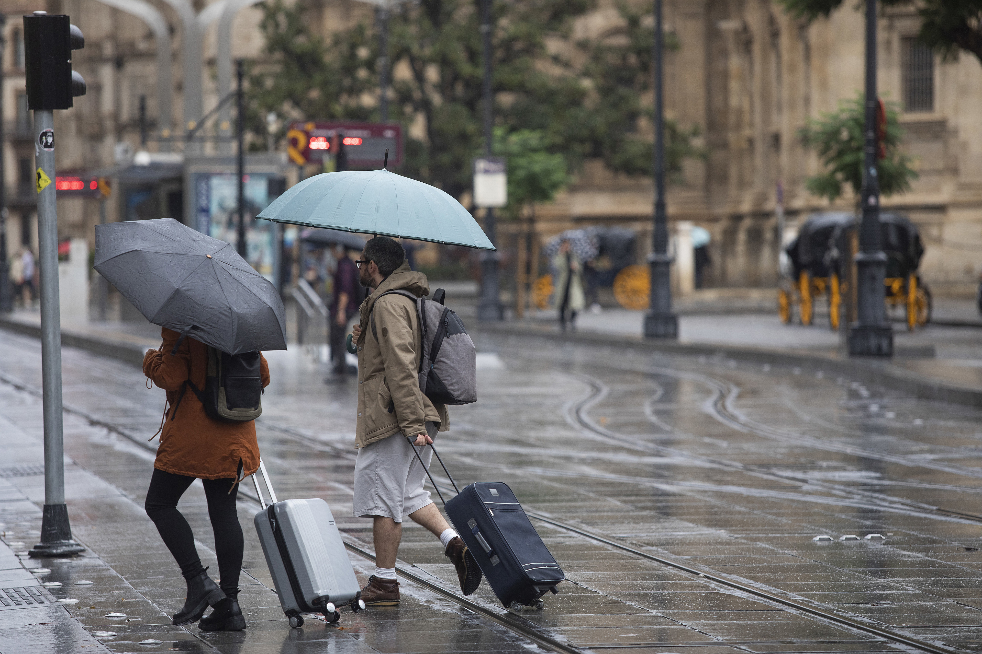 Una pareja se protege de la lluvia bajo sus paraguas el pasado 21 de octubre en Sevilla. 