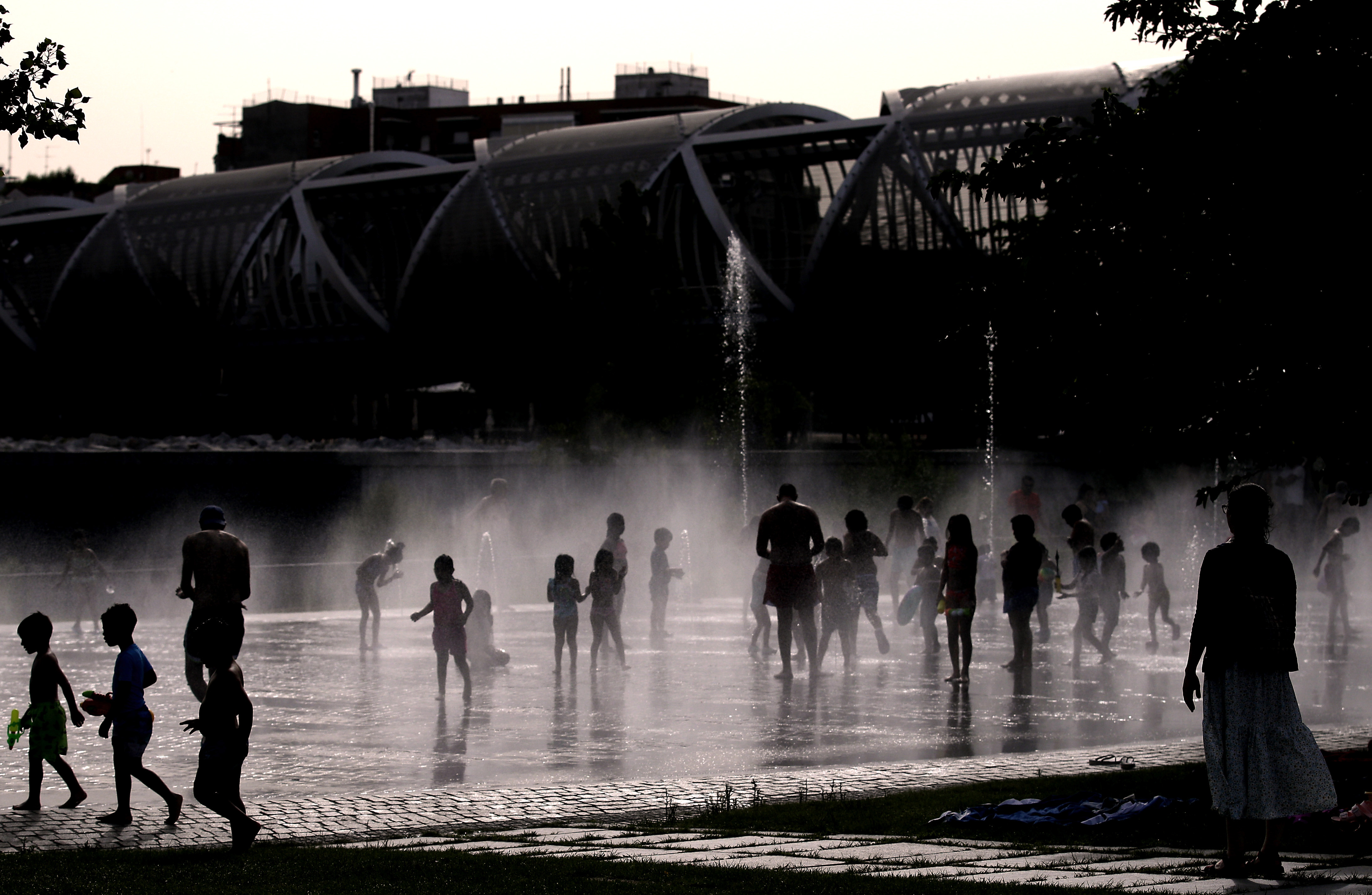Decenas de personas se refrescan en Madrid Río durante la ola de calor de junio.