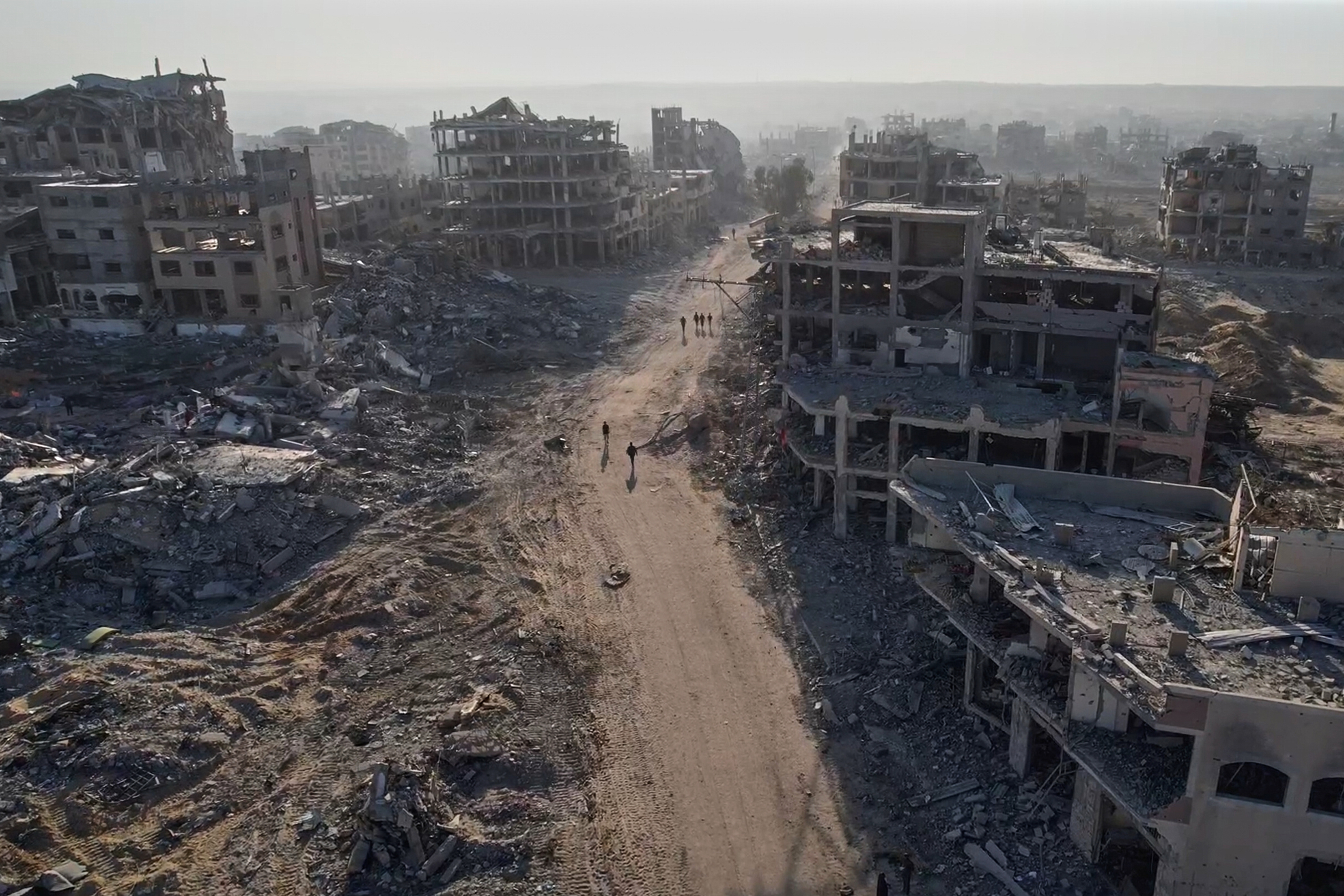 This frame grab from a drone video shoot on Saturday, Oct. 11, 2025, shows Palestinians walking surrounded by destroyed buildings in Gaza City, in the northern Gaza Strip. (AP Photo)
