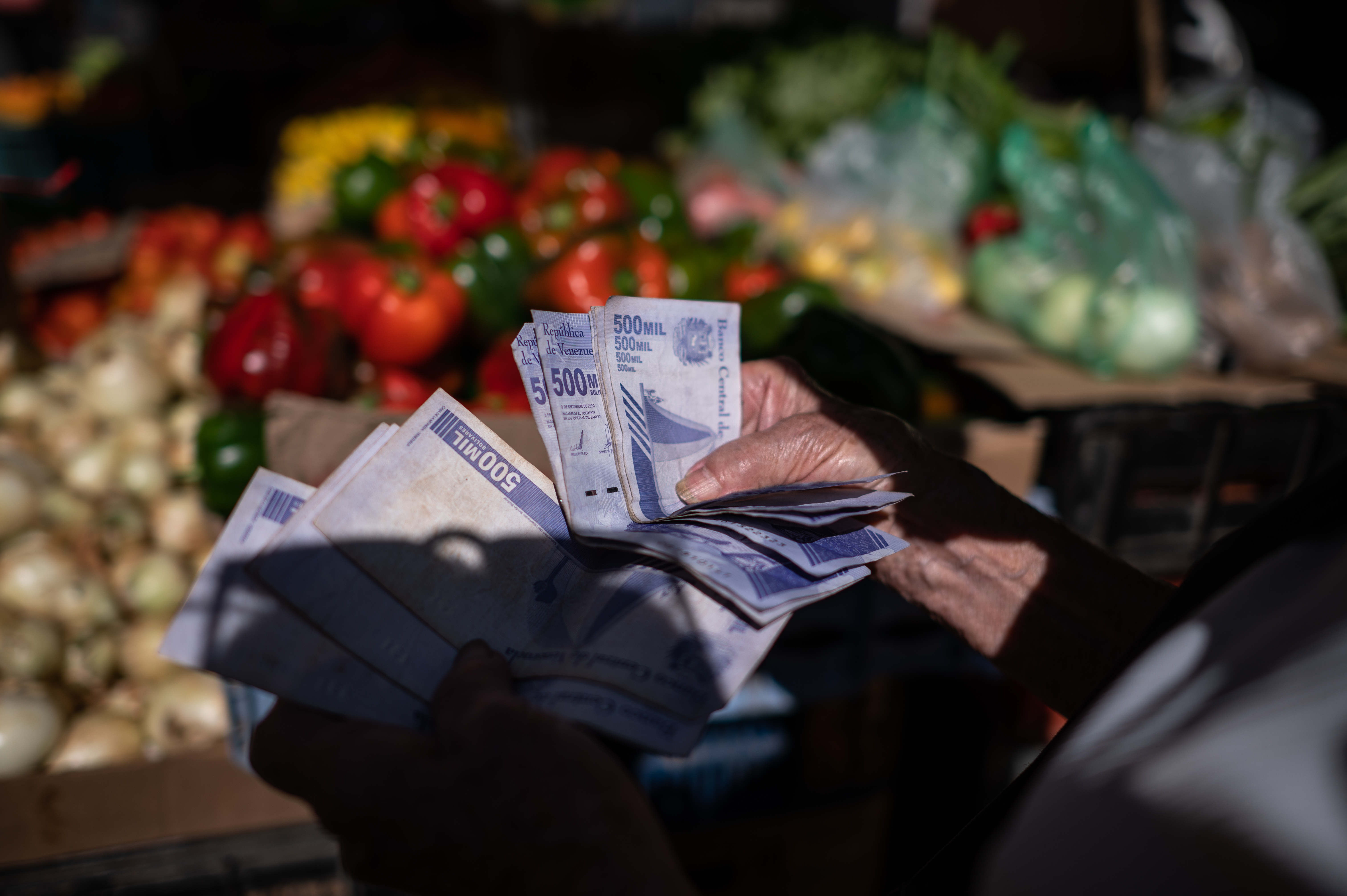 Uma mulher conta bolívares para fazer compras em um mercado de Caracas.