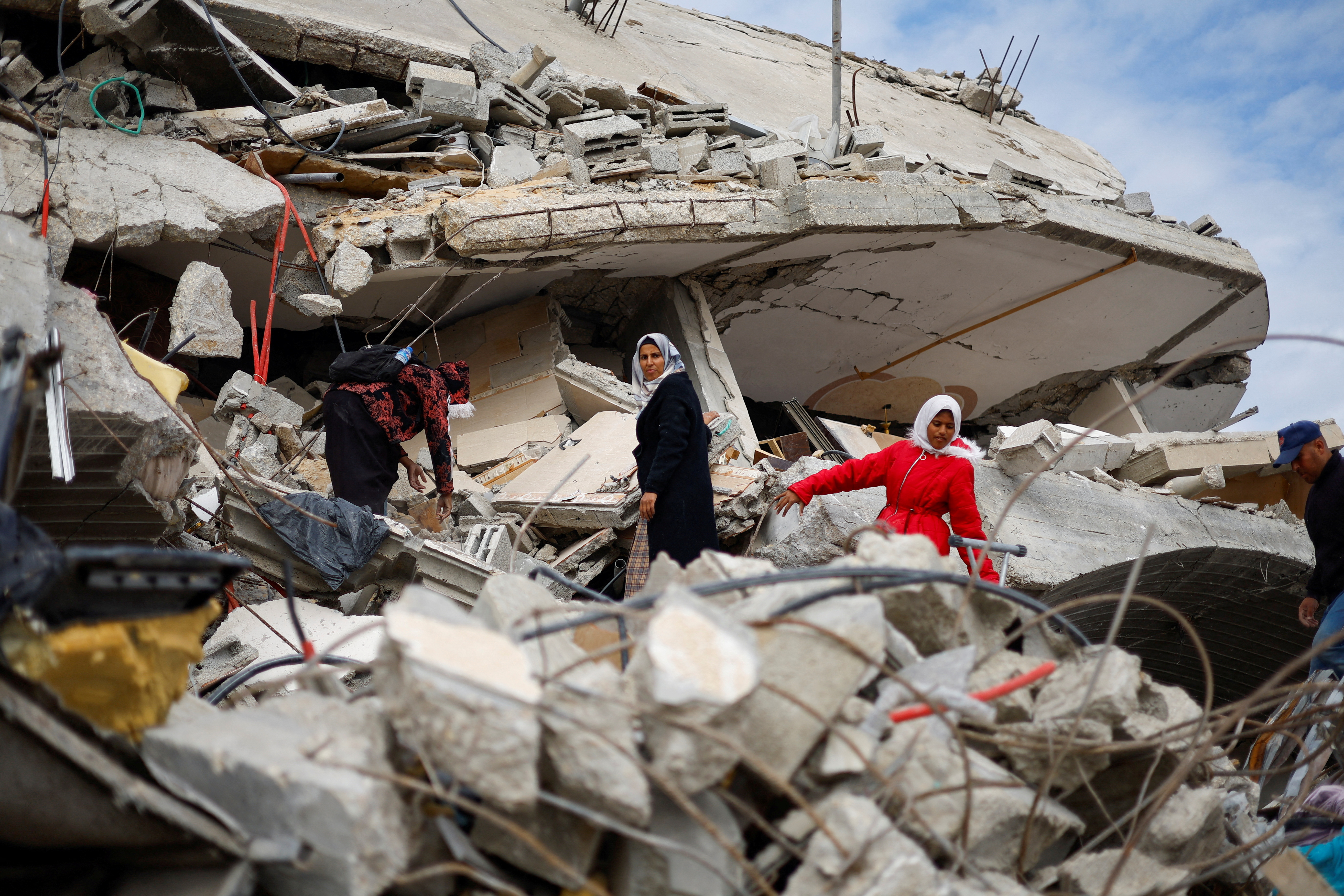 Ciudadanos palestinos caminan entre los escombros de los edificios destruidos durante una ofensiva israel, tras el alto el fuego entre Israel y Hams, en Rafah, en el sur de la franja de Gaza.