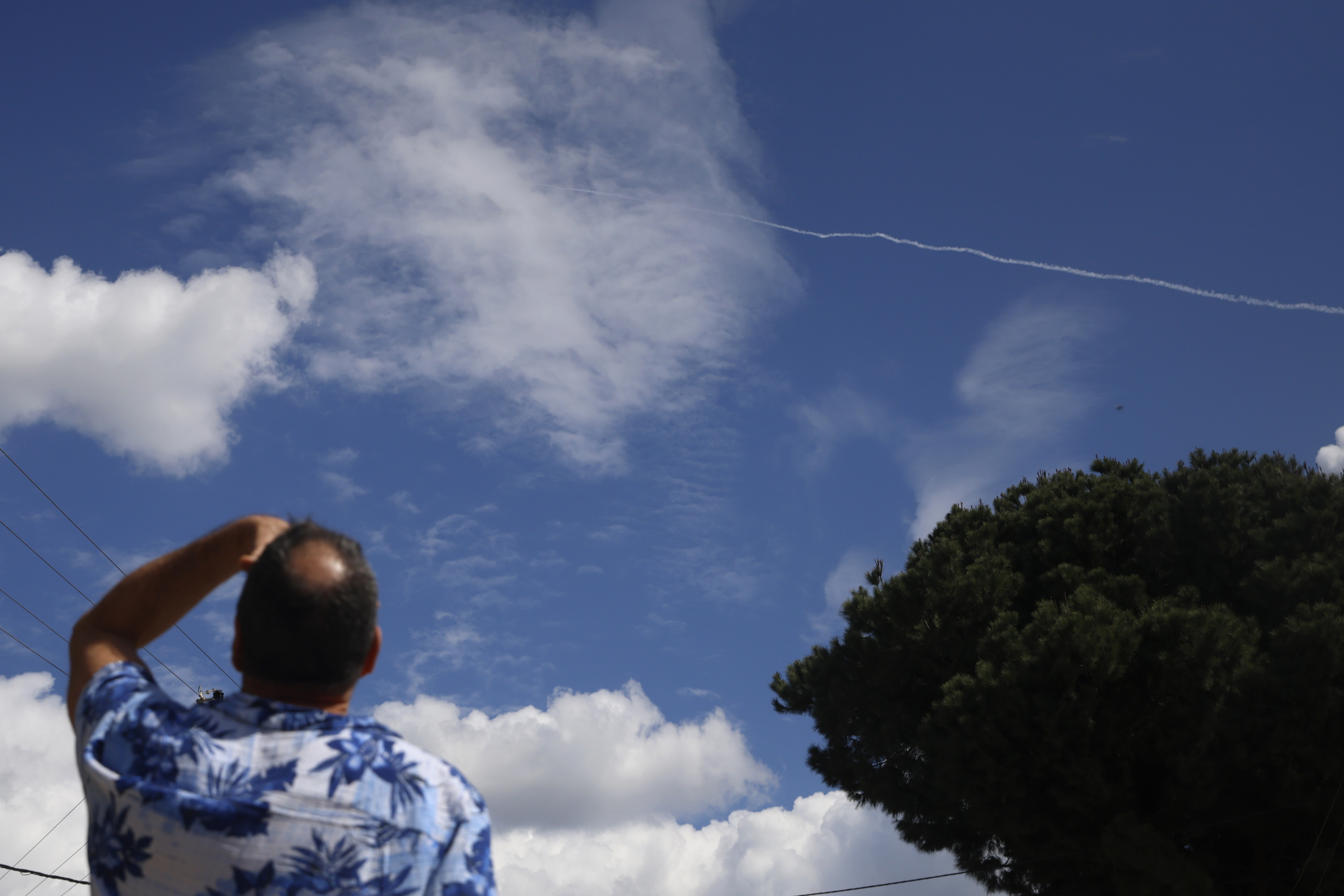 PARDES HANNA-KARKUR, ISRAEL - FEBRUARY 28: An Israeli looks up at the sky at a trail of smoke after a missile was intercepted on February 28, 2026 in Pardes Hanna-Karkur, Israel. Iran launched a wave of missiles at Israel after the United States and Israel launched a joint attack on Iran early this morning. Israel's Defense Minister Israel Katz declared a state of emergency, as Israelis braced for the retaliation. (Photo by Amir Levy/Getty Images)