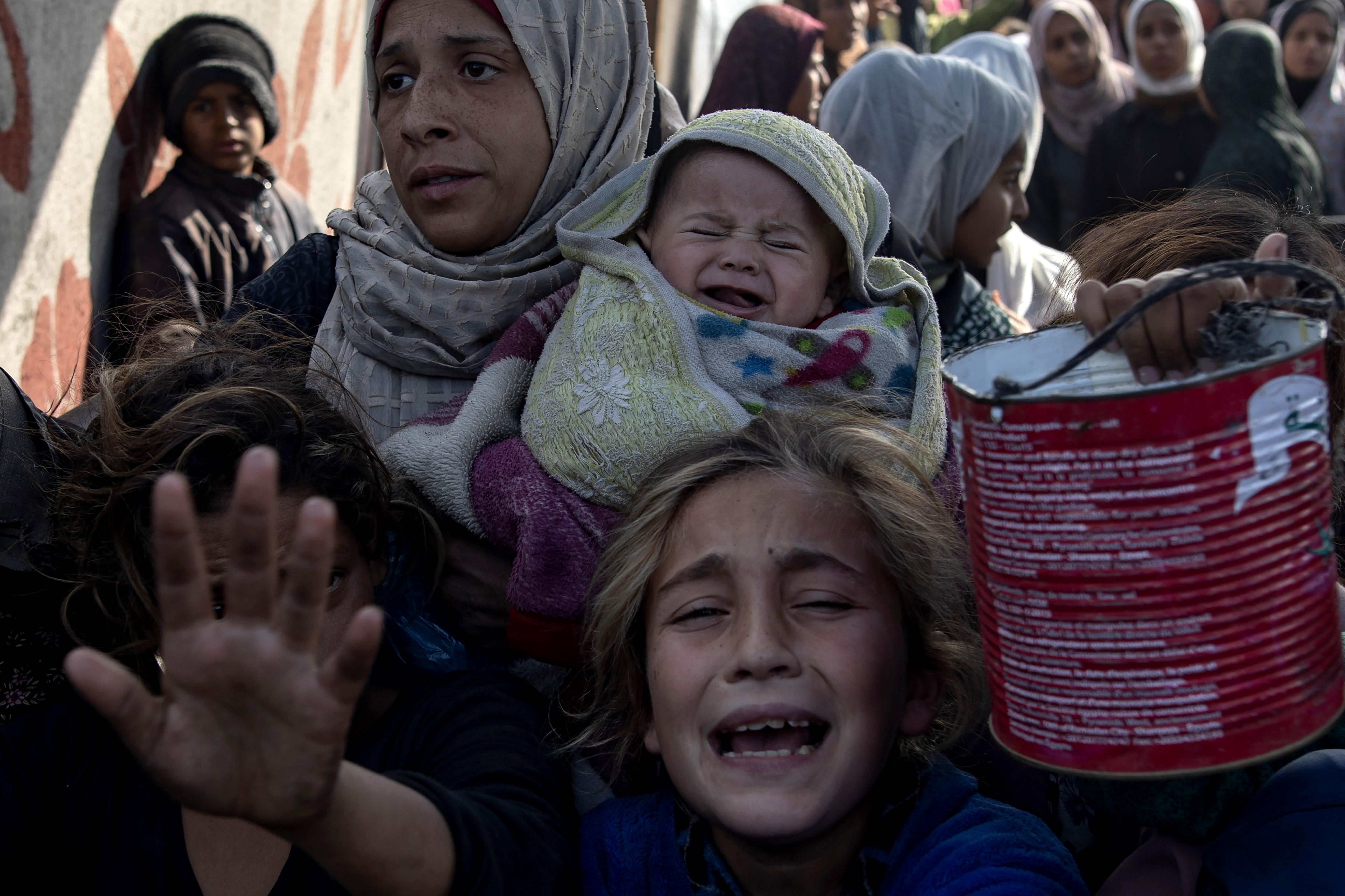 Un grupo de personas se amontonan en Jan Yunis, en el sur de Gaza, para recibir comida en una cocina comunitaria, este viernes 10 de enero de 2025.