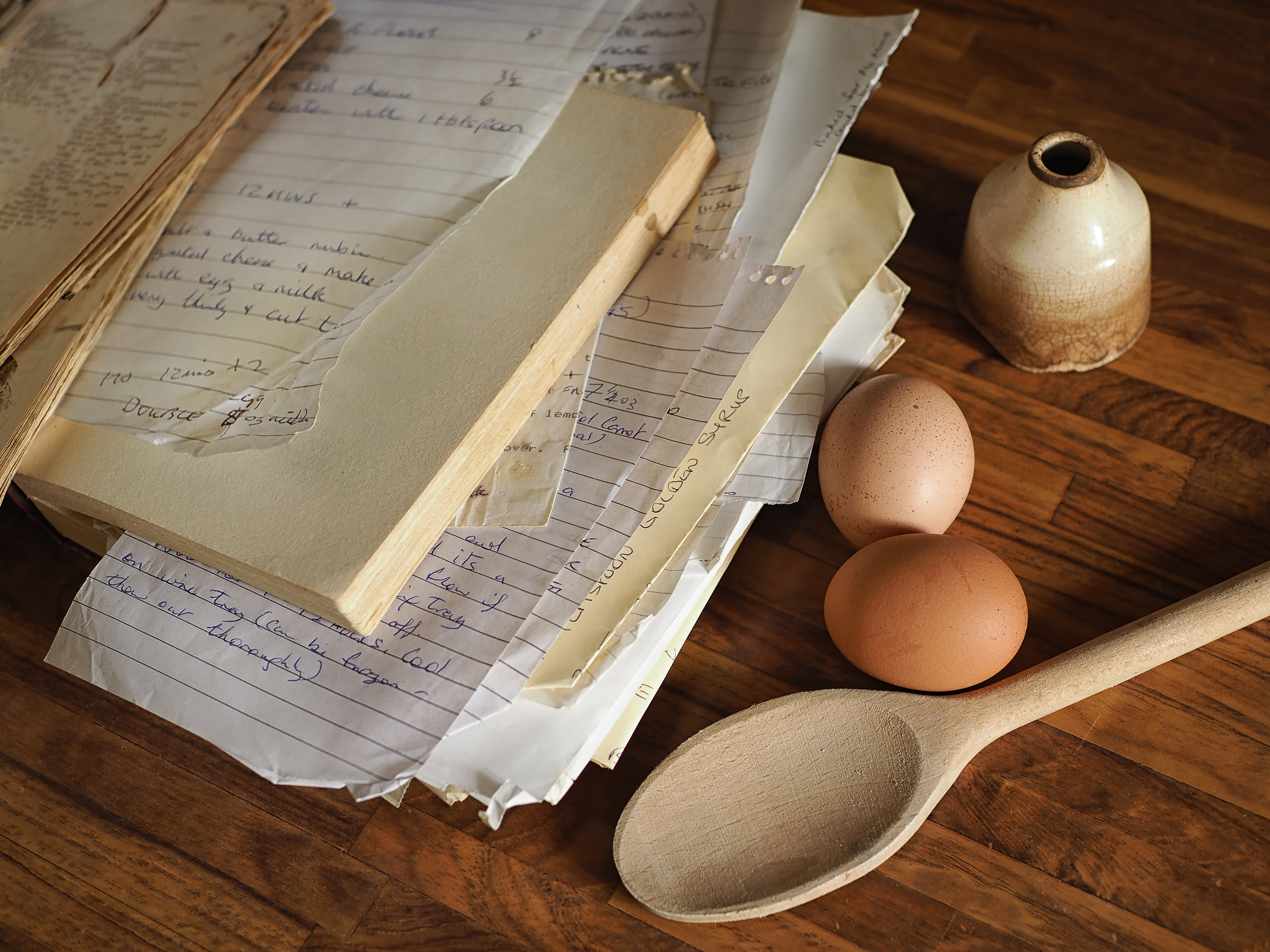 Utensilios de cocina como guantes para horno, cucharas de madera y pizarra  para anotar el menú.