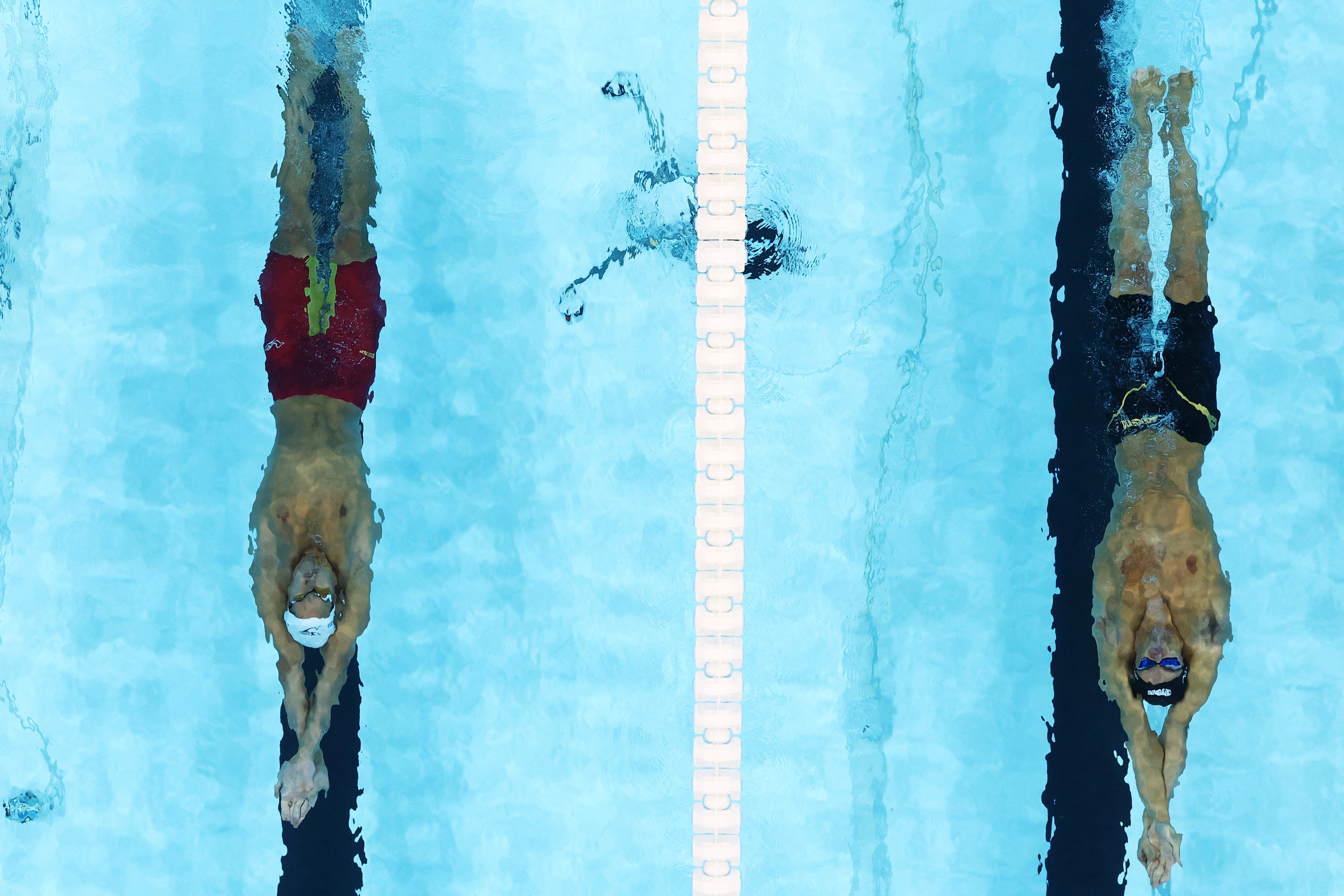 Paris 2024 Olympics - Swimming - Men's 100m Backstroke - Heats - Paris La Defense Arena, Nanterre, France - July 28, 2024.   Thomas Ceccon of Italy and Hugo Gonzalez of Spain in action. REUTERS/Marko Djurica