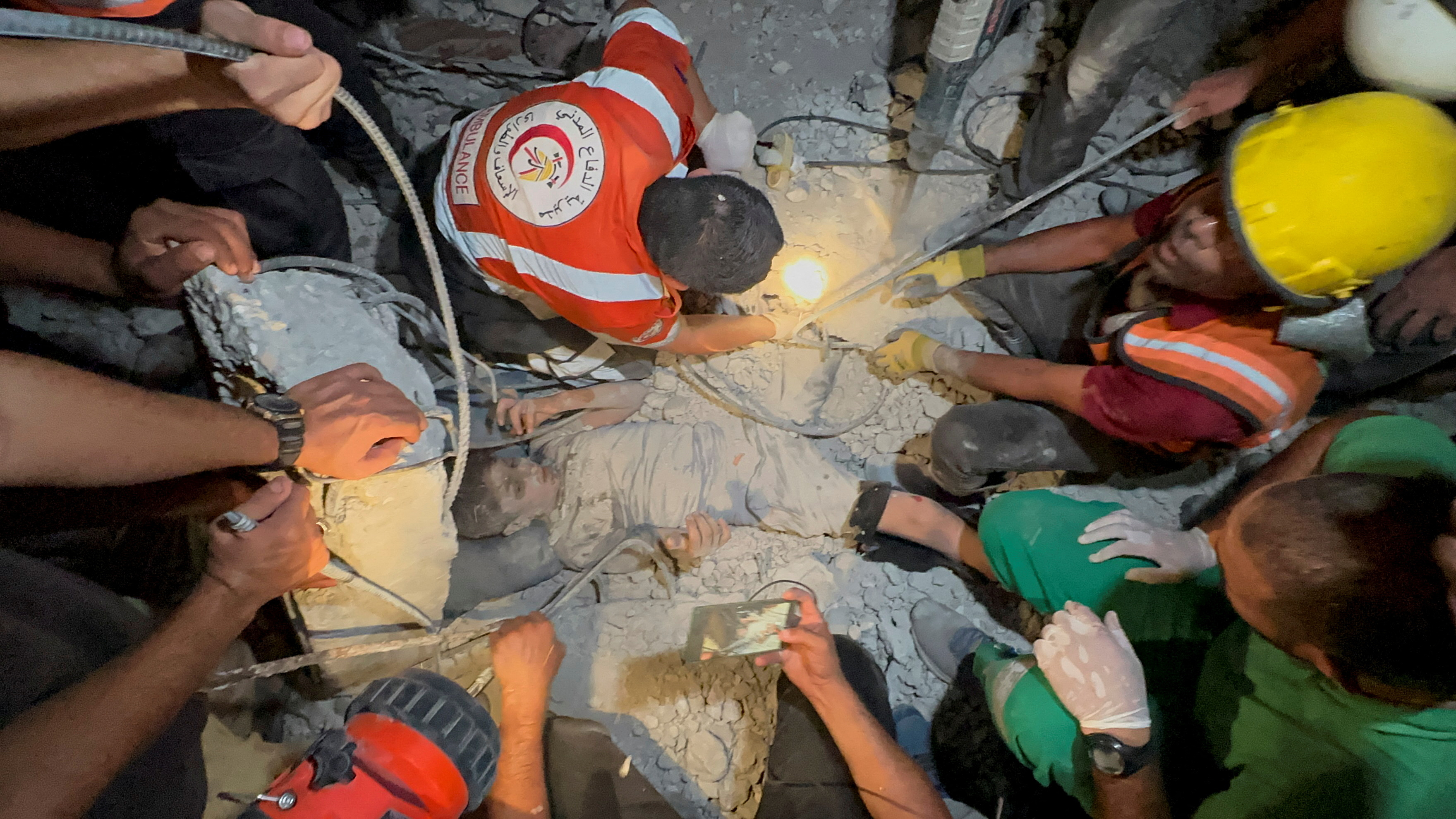 Palestinians work to rescue a child from under the rubble following an Israeli strike, amid the Israel-Hamas conflict, in Nuseirat in the central Gaza Strip, September 12, 2024. REUTERS/Hatem Hani     TPX IMAGES OF THE DAY