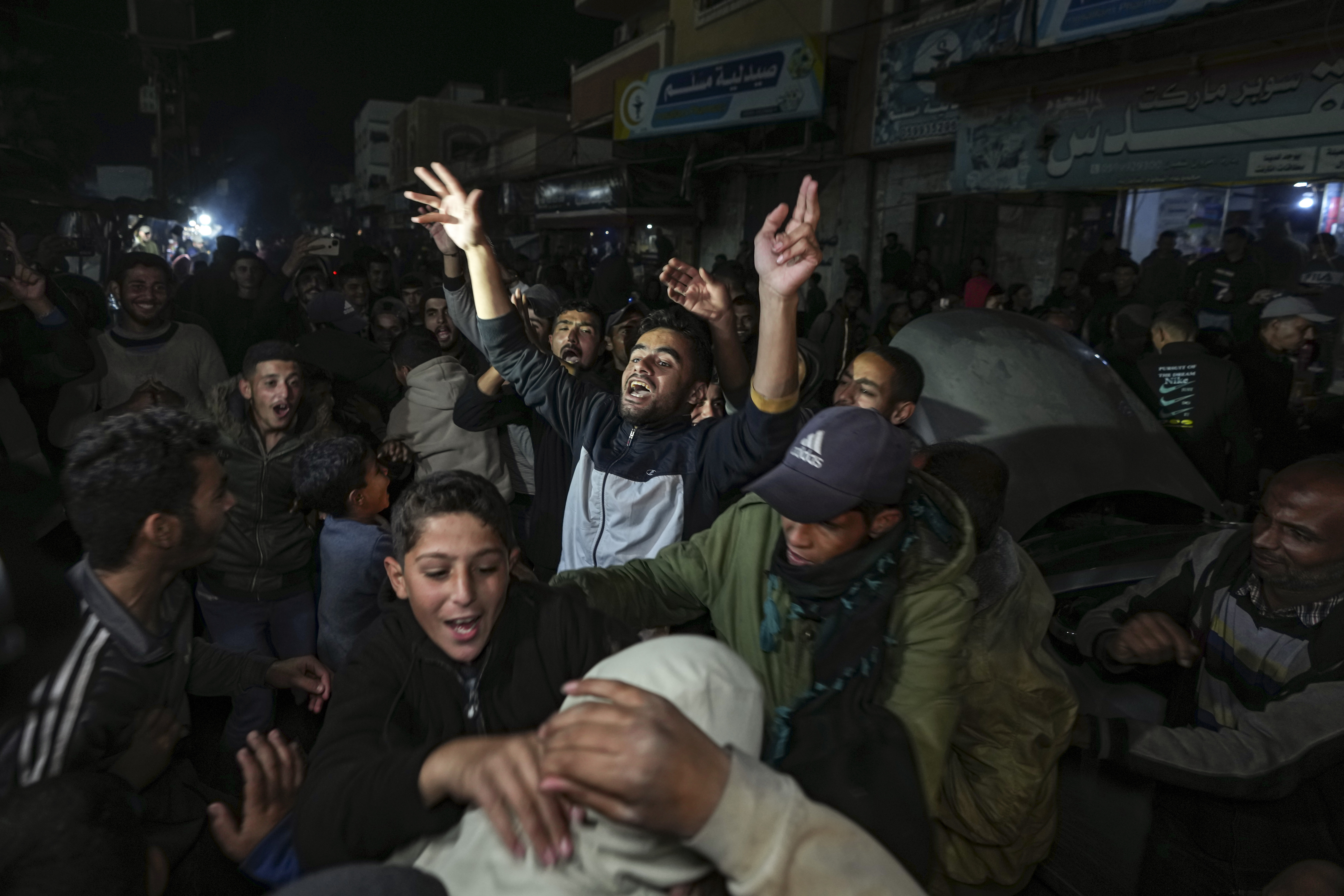 Ciudadanos palestinos celebran el anuncio de alto el fuego entre Hams e Israel en Deir al Balah, en el centro de Gaza.