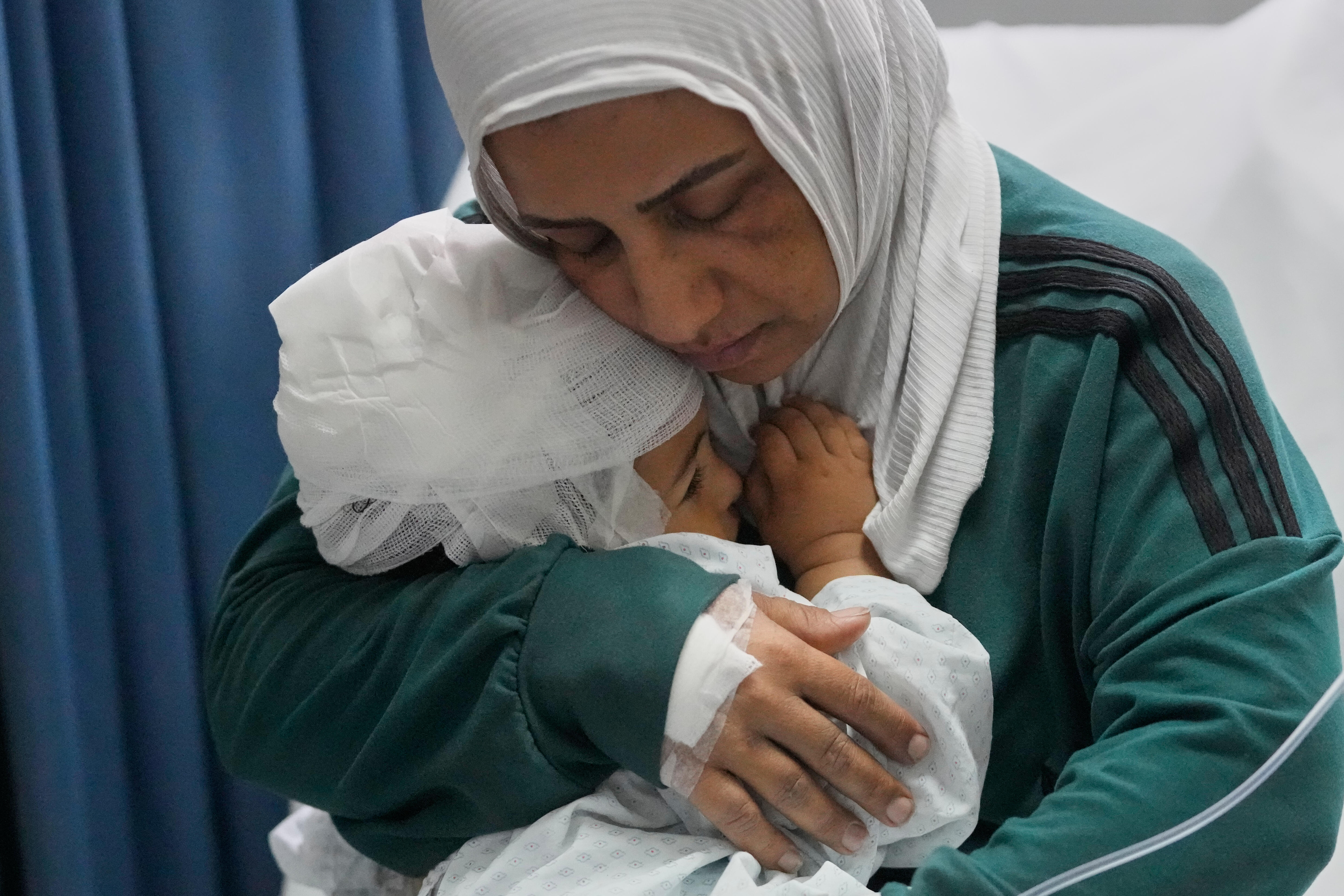 Una madre sostiene a su hijo de 18 meses, tras haber sido operado de la cabeza por heridas recibidas en un ataque israelí, en Tiro, Líbano, este miércoles 27 de mayo.