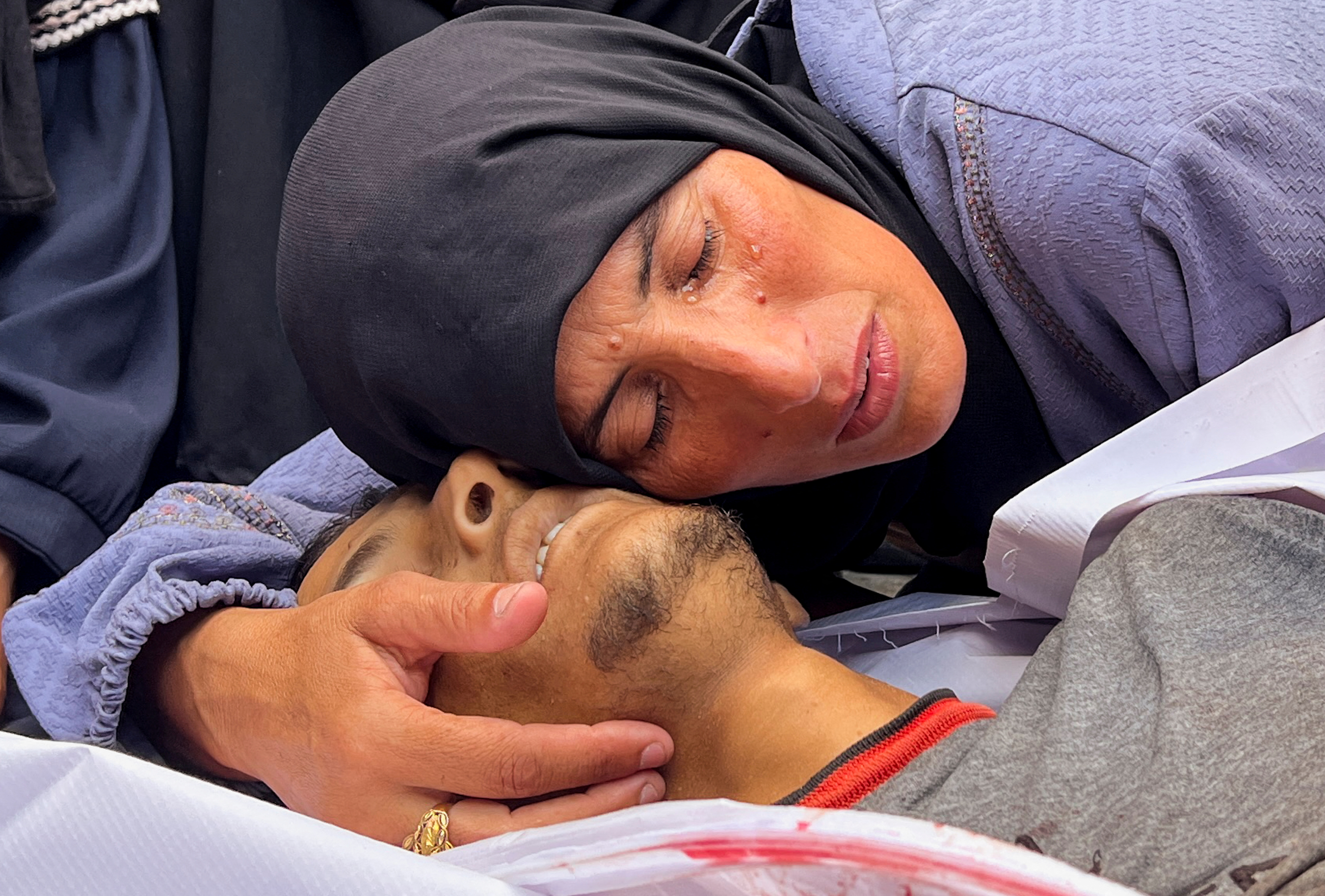 La madre de Hesham Ifsifis, asesinado por fuego israelí en un punto de reparto de comida, según fuentes médicas, vela s cuerpo en el Hospital Nasser de Jan Yunis, este sábado.