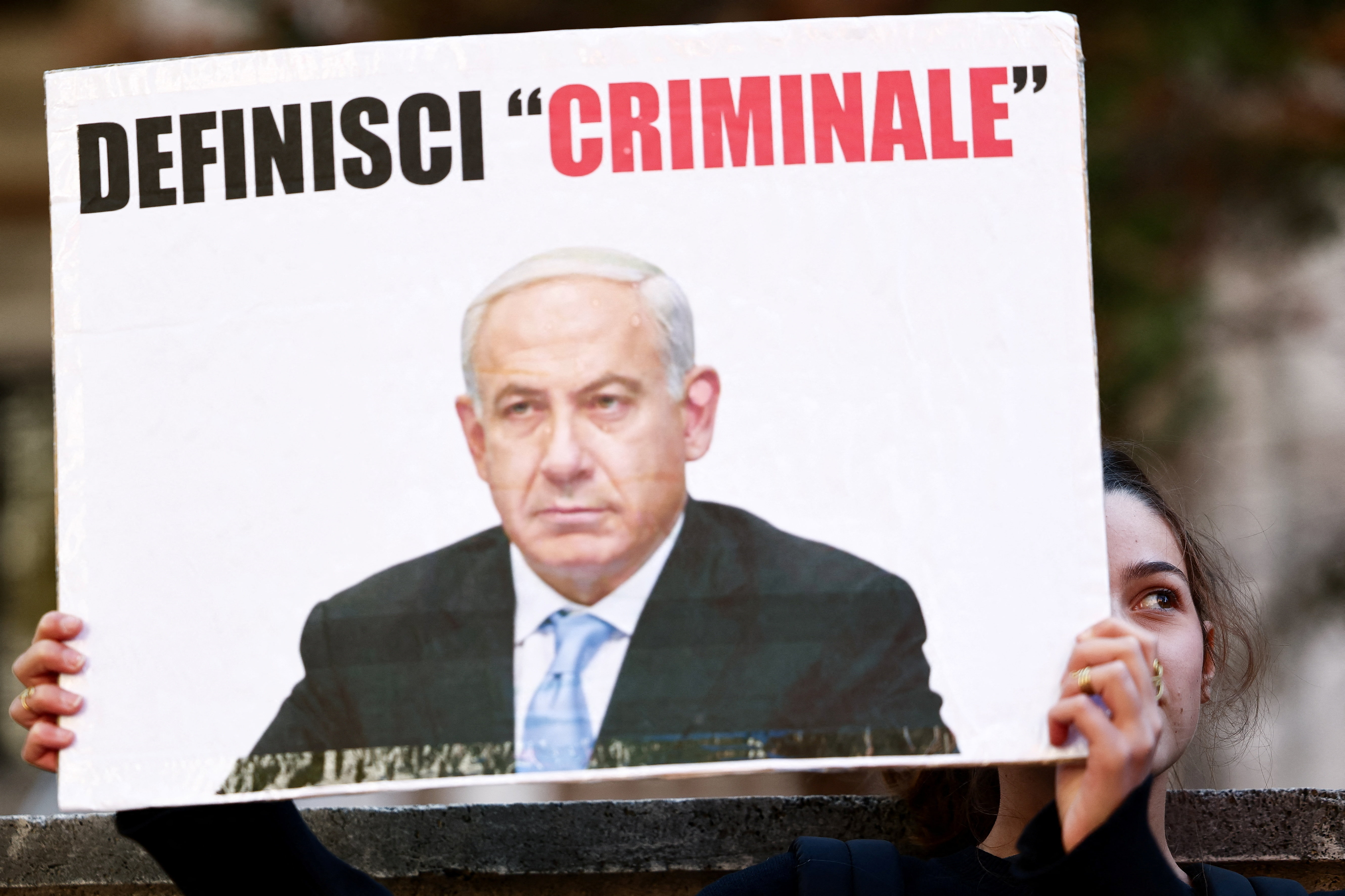 A pro-Palestinian demonstrator holds a placard that reads: "Define a criminal" at a protest during a nationwide strike called by the USB union to condemn the Israeli forces' interception of the Global Sumud Flotilla vessels aiming to reach Gaza and break Israel's naval blockade, in Rome, Italy, October 3, 2025. REUTERS/Yara Nardi