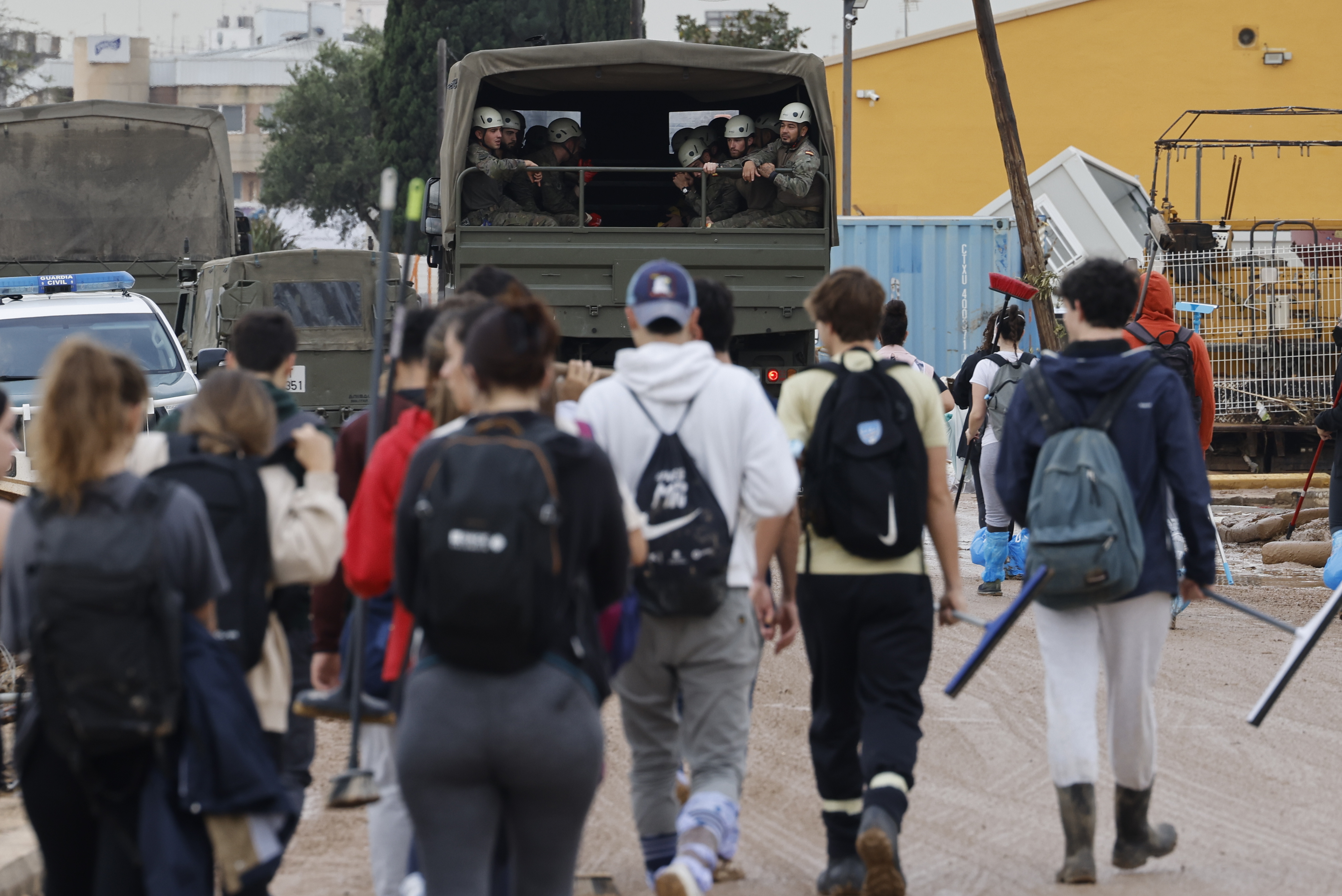 Voluntarios caminan tras un camión del ejército en dirección a Paiporta, este lunes.