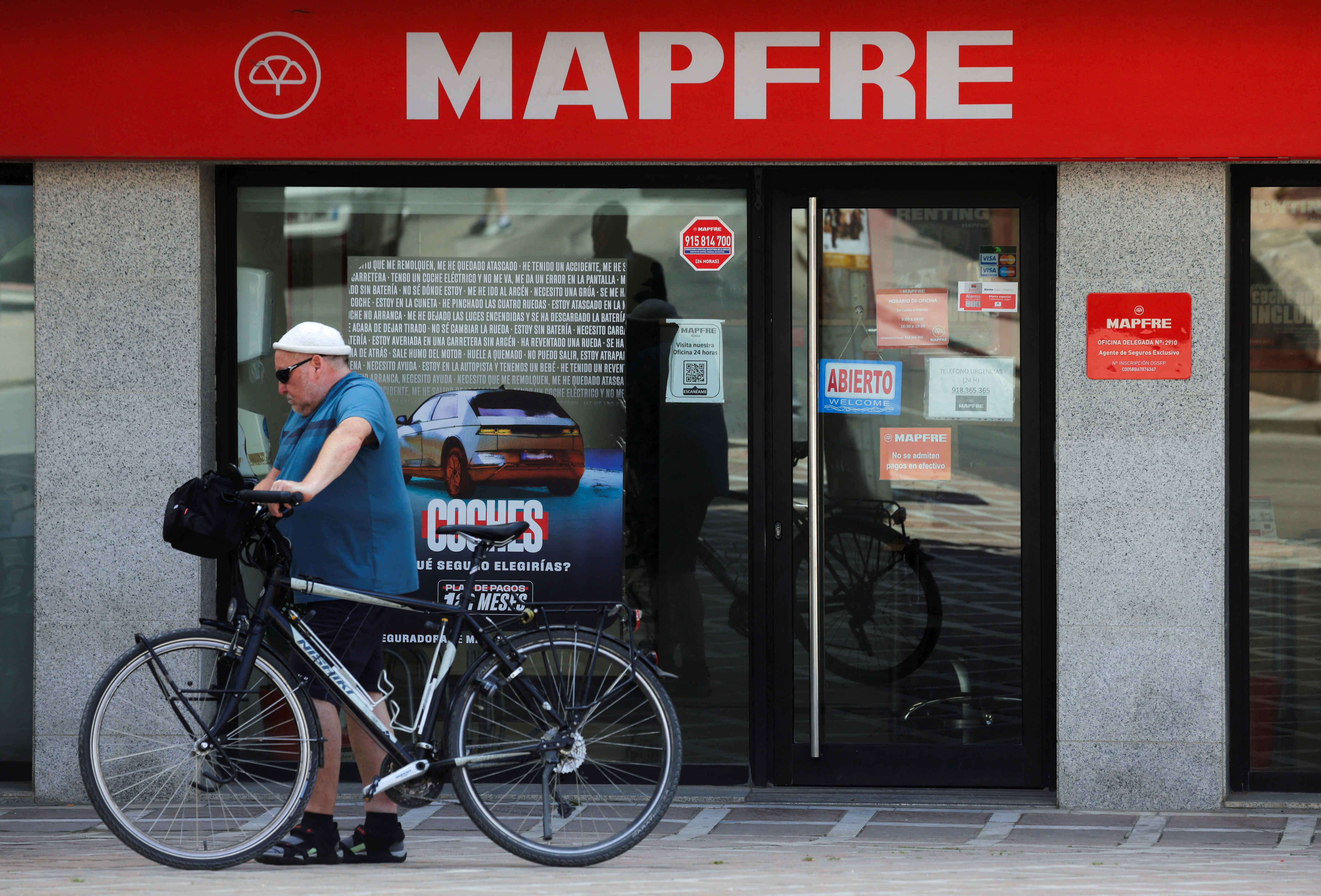 Una persona pasa delante de una sucursal de Mapfre, en Ronda (Málaga).