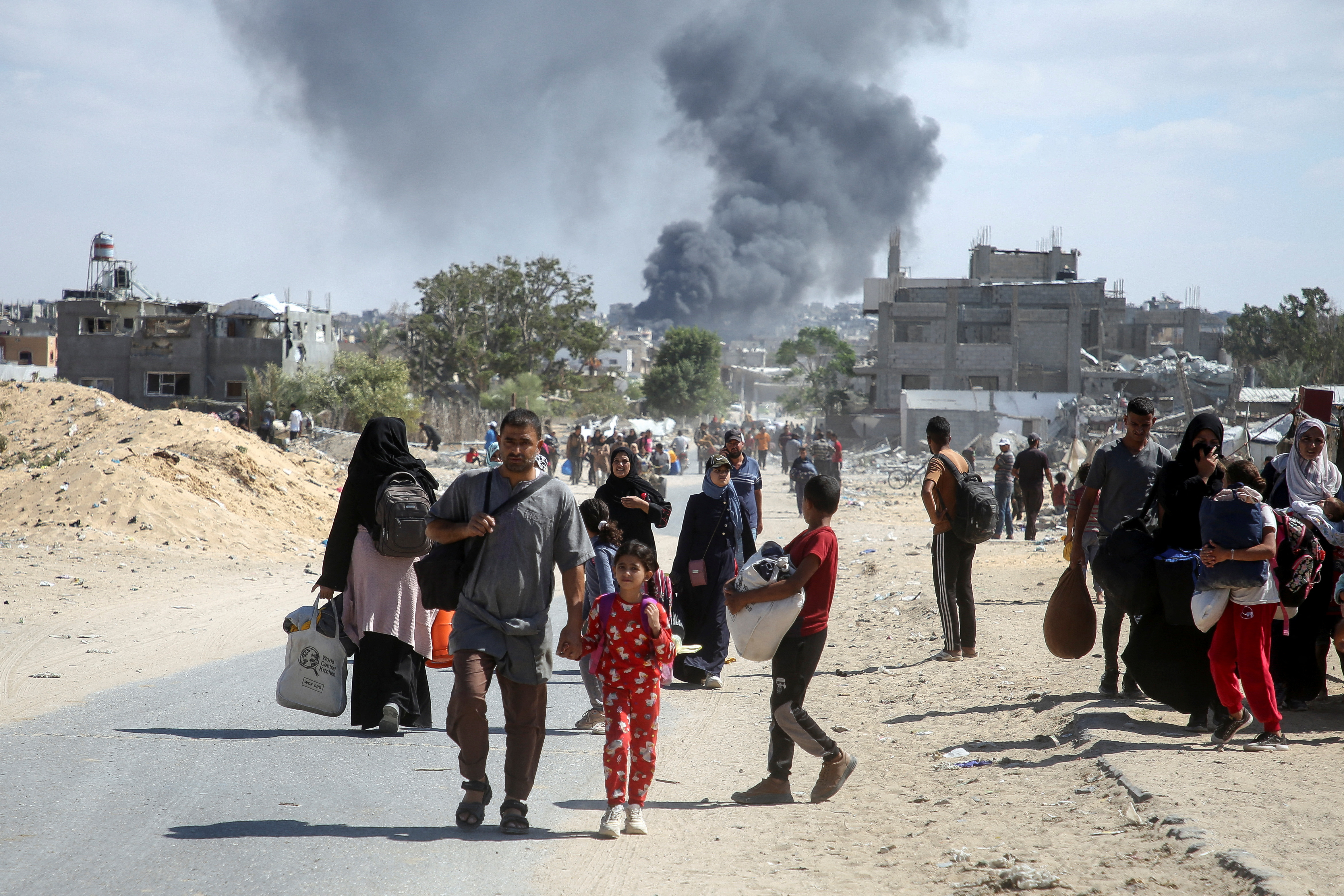 Smoke rises following an Israeli strike as displaced Palestinians make their way to flee areas in the eastern part of Khan Younis following an Israeli evacuation order, amid the ongoing conflict between Israel and Hamas, in Khan Younis in the southern Gaza Strip October 7, 2024. REUTERS/Hatem Khaled