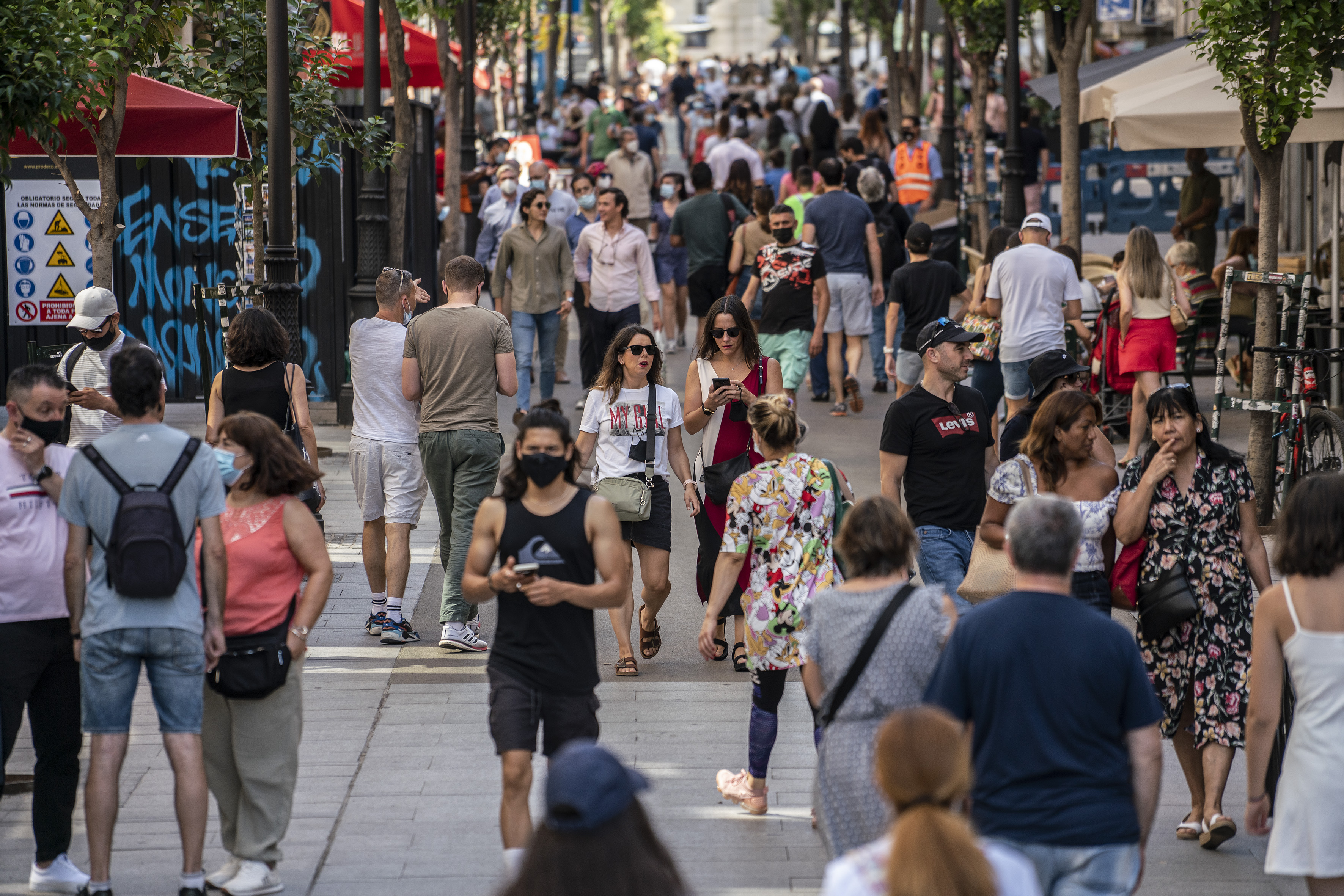 Decenas de personas, en una calle del centro de Madrid, en junio de 2021.