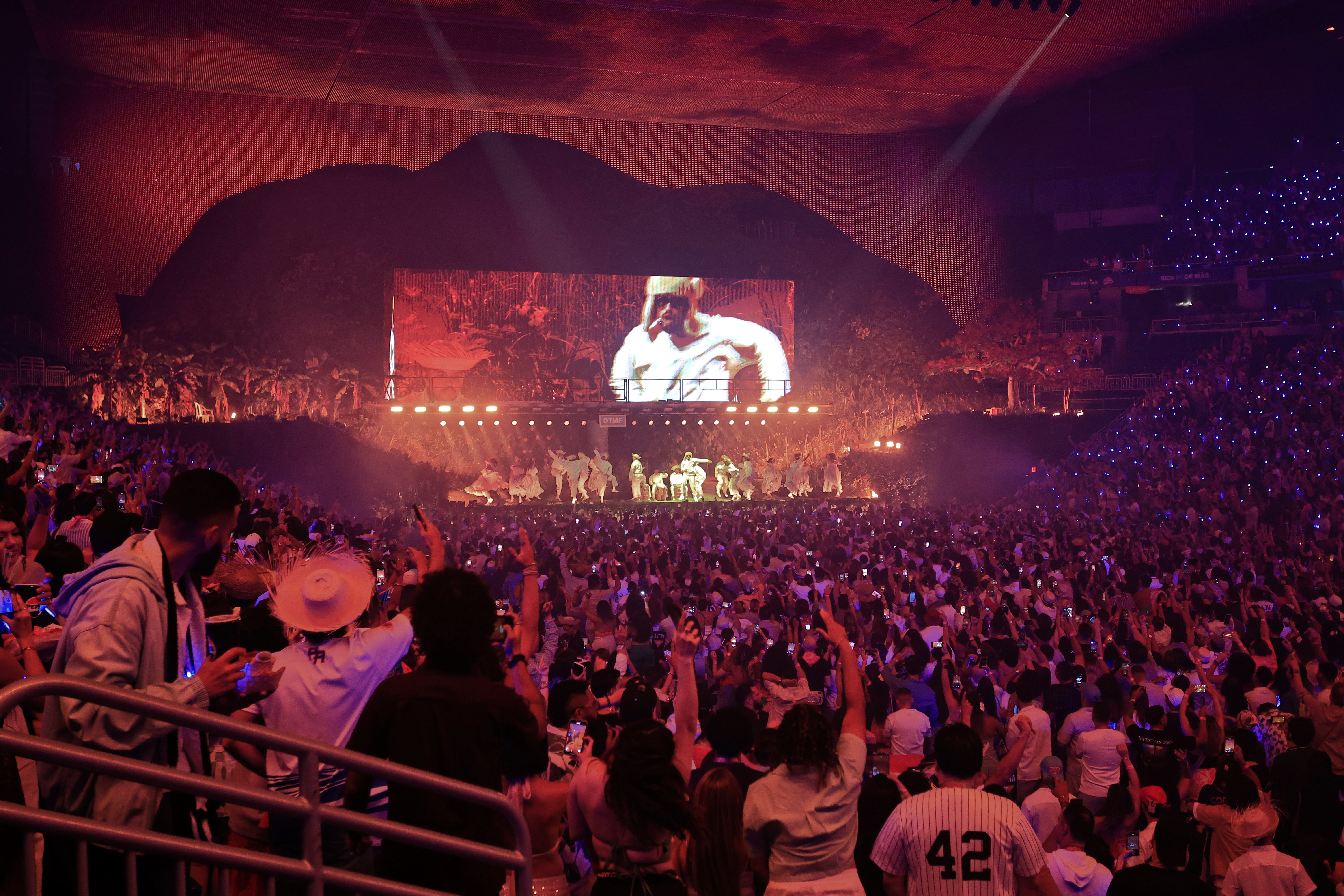 Bad Bunny performing on stage during concert with dynamic lighting and crowd