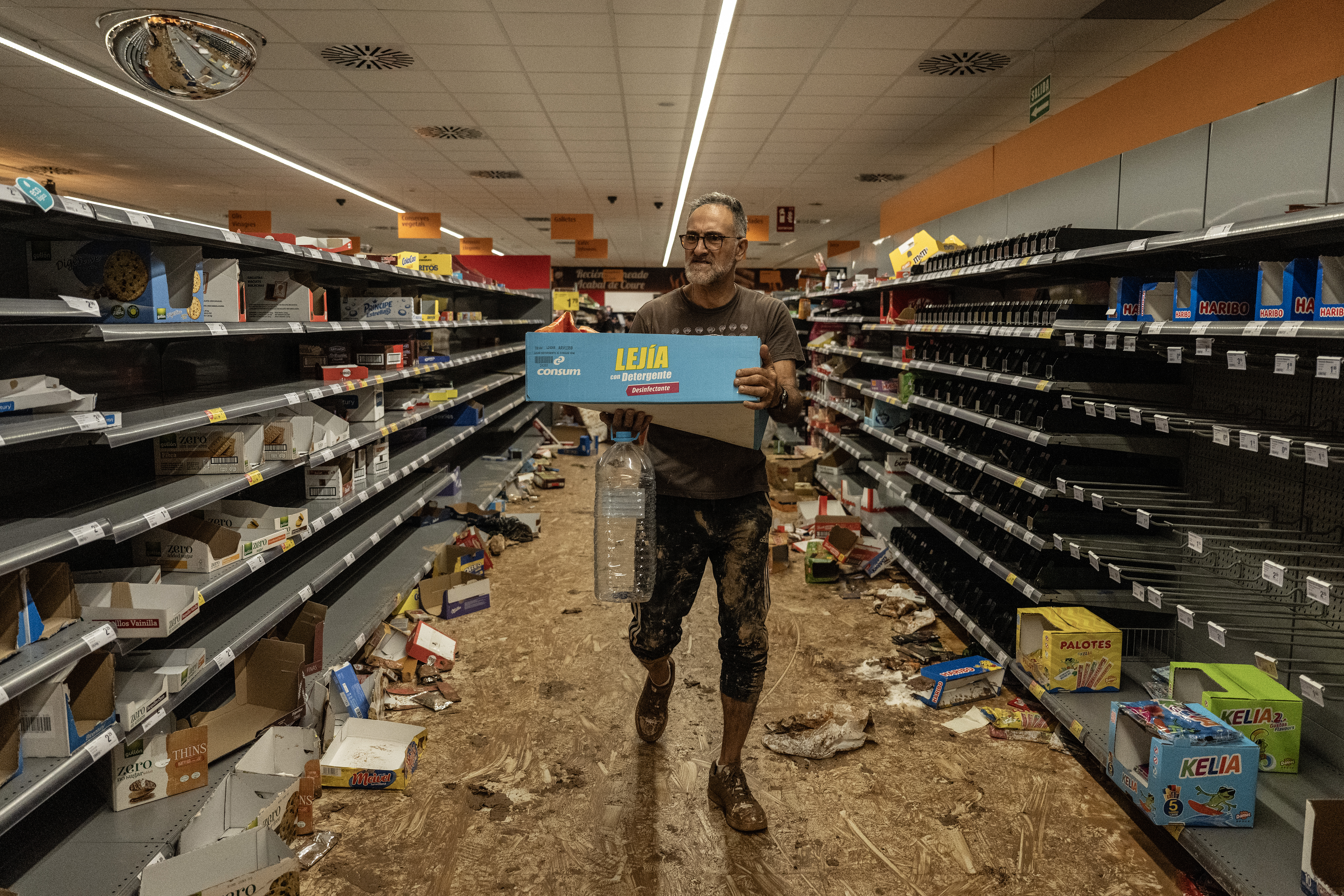 Un hombre recoge productos en un supermercado Consum que fue saqueado después del paso de la dana en Paiporta (Valencia), este jueves 31 de octubre.