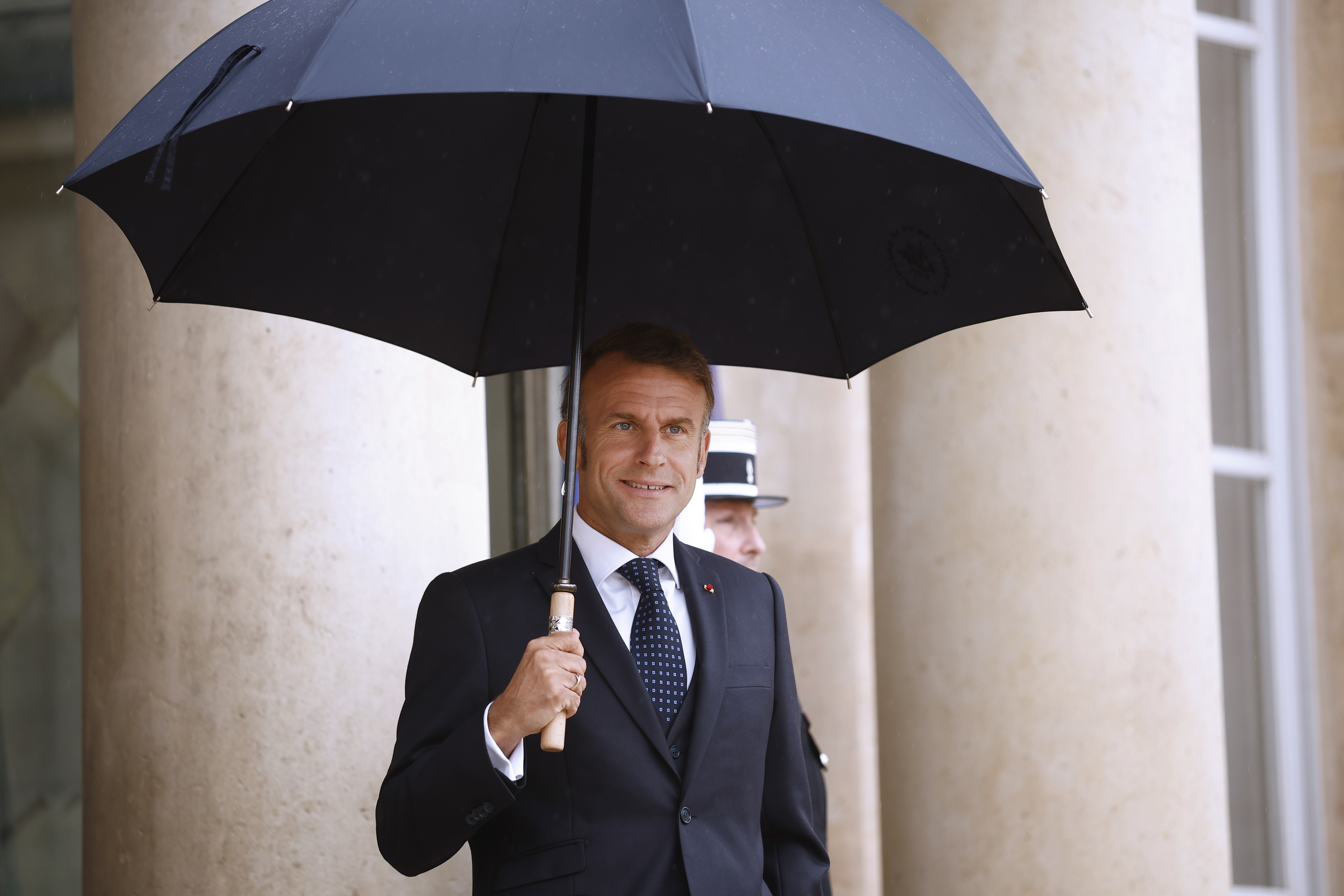 Paris (France), 24/07/2025.- French President Emmanuel Macron holds an umbrella as he awaits the Lebanese Prime Minister Nawaf Salam (not pictured) upon his arrival at the Elysee Palace in Paris, France, 24 July 2025. This marks the first official visit of the Lebanese prime minister to France, with the purpose to reaffirm the diplomatic relationship between the two countries. (Francia, Líbano) EFE/EPA/YOAN VALAT
