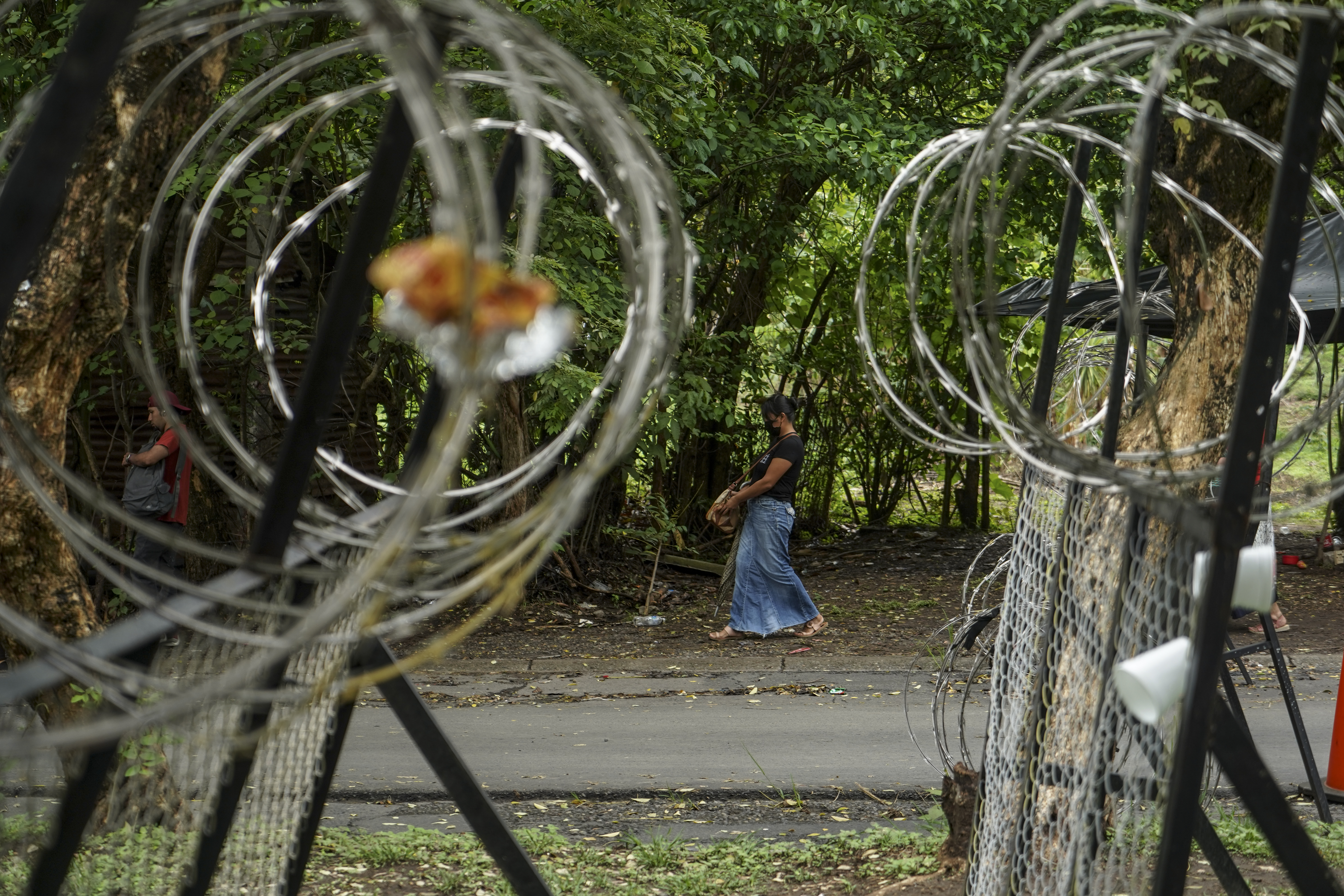 Uma mulher passa por um posto de controle militar em Tonacatepeque, El Salvador. 