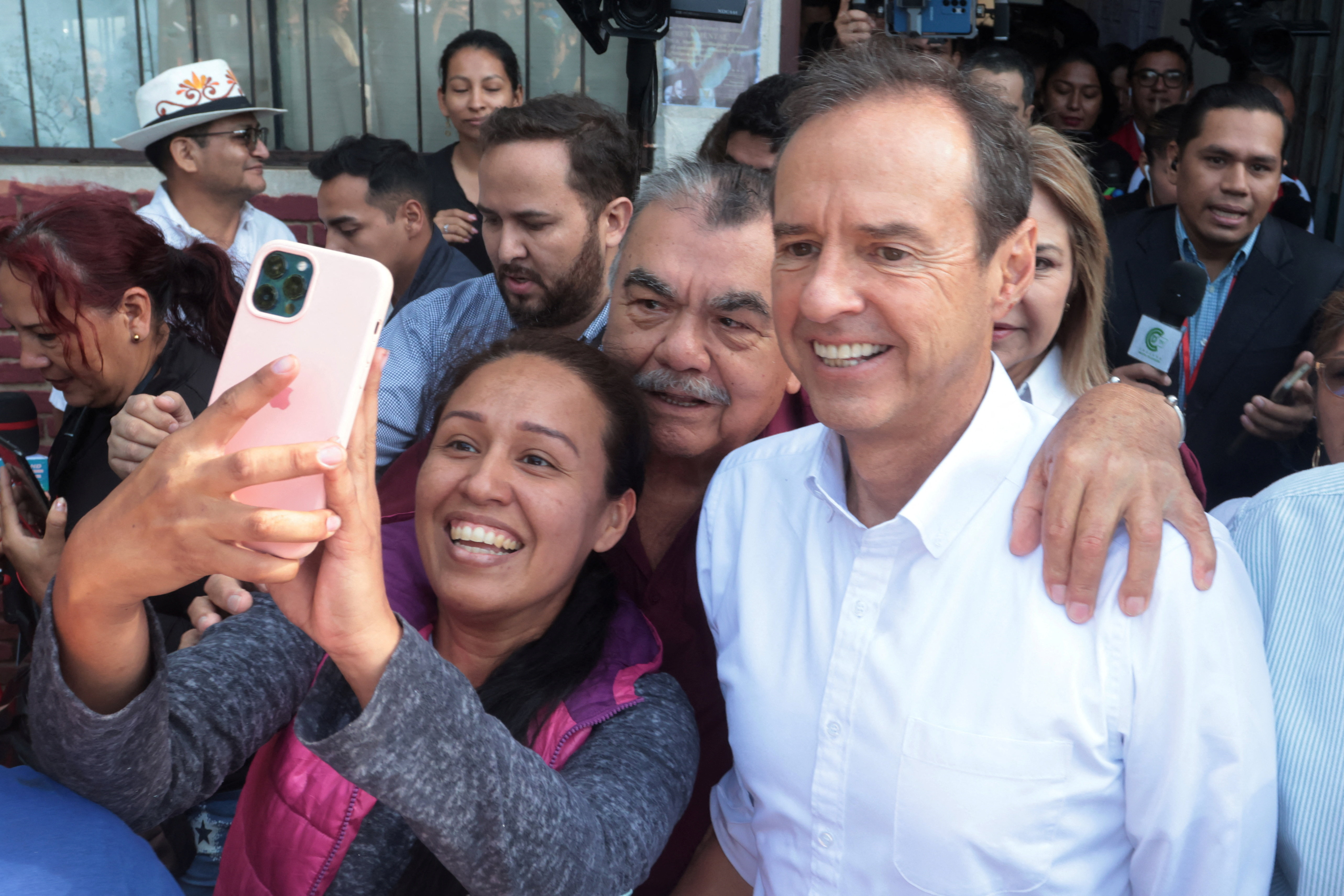 Conservative Bolivian former President Jorge "Tuto" Quiroga, presidential candidate for the Alianza Libre Coalition, poses for a selfie with a supporter, on the day of the runoff election in Santa Cruz, Bolivia, October 19, 2025. REUTERS/Ipa Ibanez