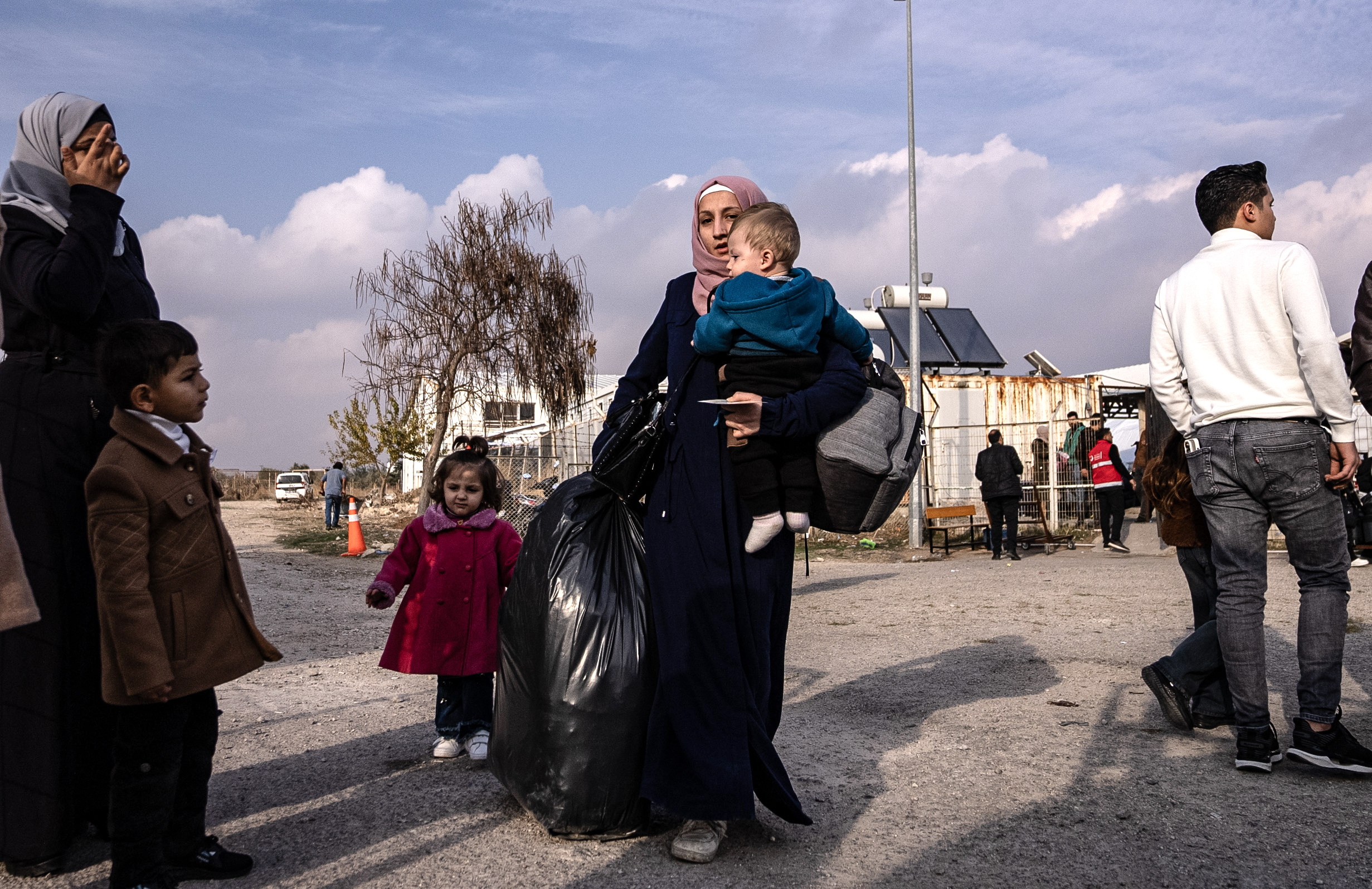 Una mujer siria con un ni?o carga su equipaje mientras espera cruzar a Siria desde Turqua este martes en la puerta fronteriza de Oncupinar, cerca de la ciudad de Kilis, en el sur de Turqua.